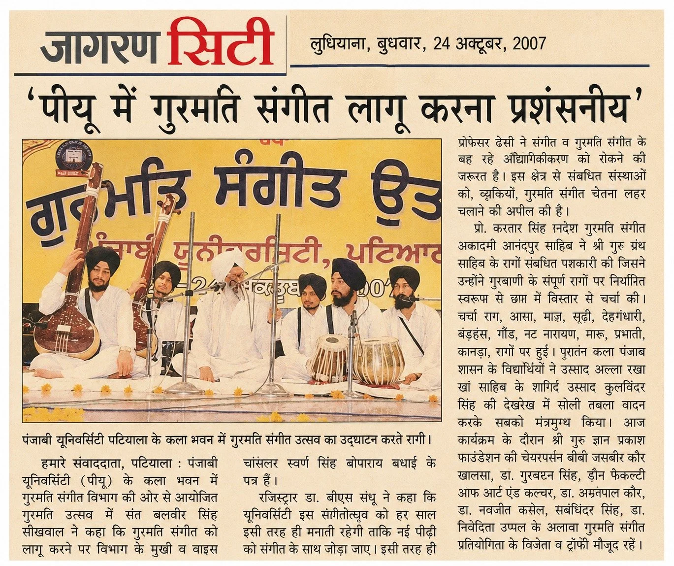 Photograph of six men dressed in traditional white Punjabi attire, sitting on stage with musical instruments, during a guitar and music festival in Punjab, India, in 2007.