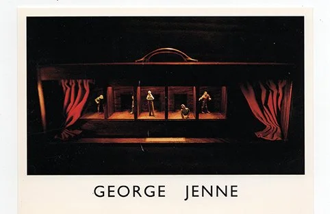 A miniature theater scene with five small figures on a stage, featuring red curtains on the sides and dim lighting, with the names 'George' and 'Jenne' written below.