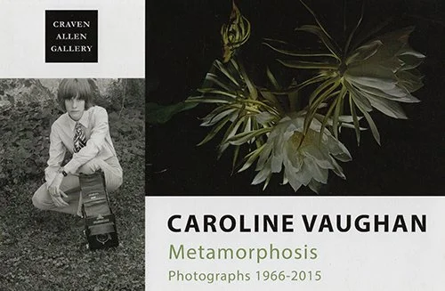 Exhibition poster for Caroline Vaughan's 'Metamorphosis' photography exhibit, featuring a black and white photo of a young person in a jacket and tie holding a camera, with green foliage and a plant image.