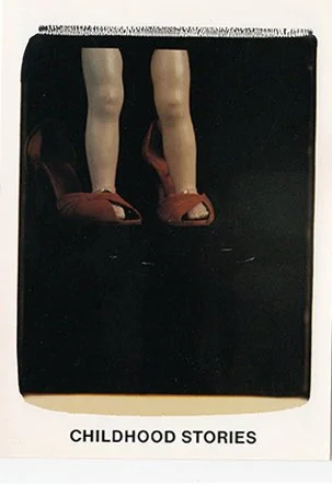 A black book cover with a pair of child legs wearing red sandals, titled 'Childhood Stories' at the bottom.