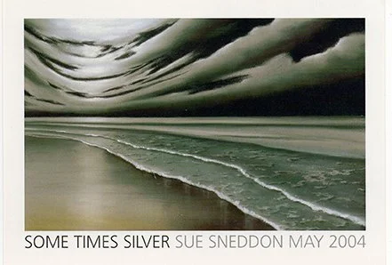 A black and white photograph of a cloudy sky over a beach with a small wave. Stringed text at the bottom reads, 'SOME TIMES SILVER SUE SNEDDON MAY 2004.'