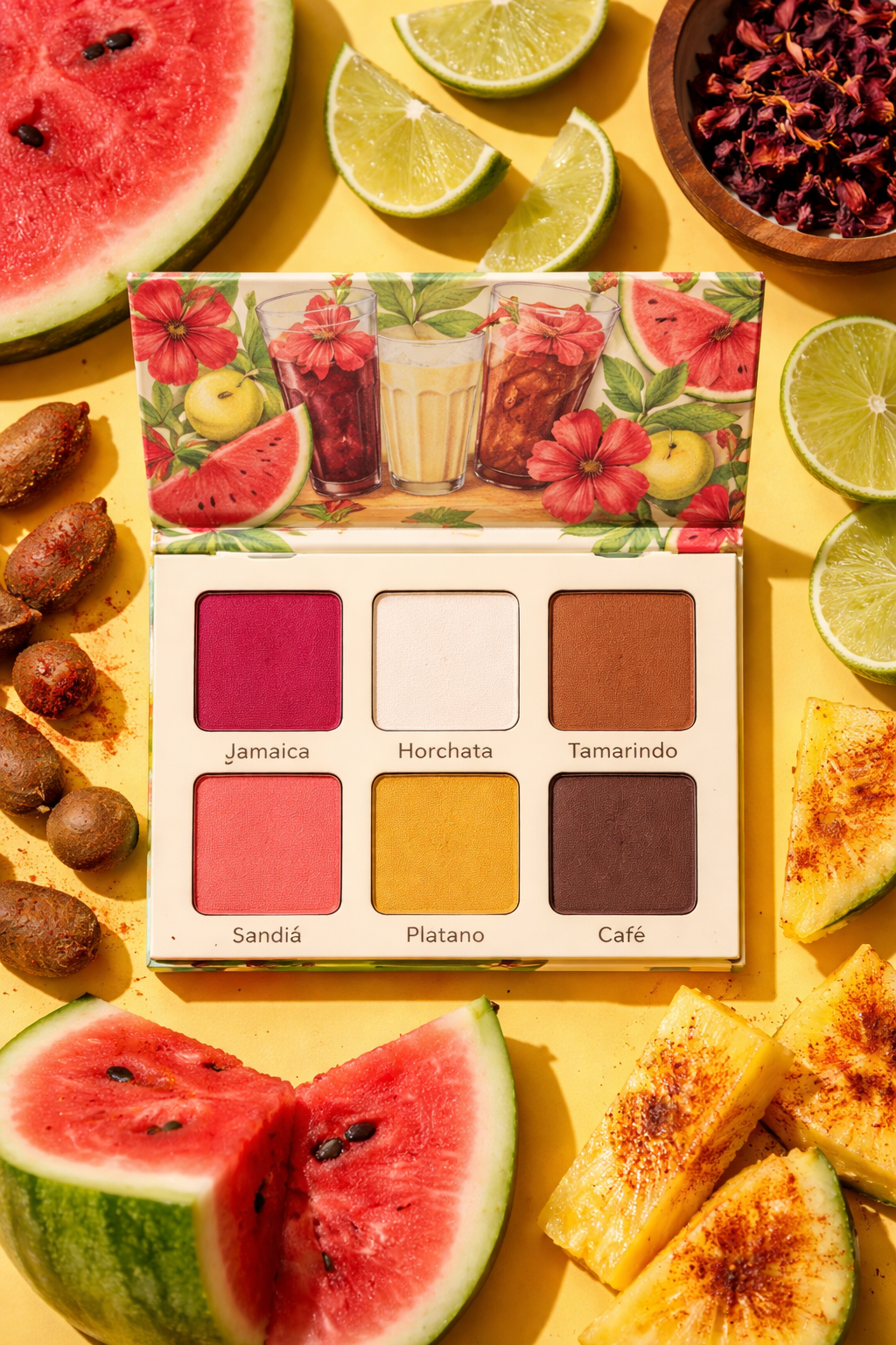 Eyeshadow palette with bright pink, white, yellow, and brown eyeshadows surrounded by slices of watermelon, lime, banana, and other fruits on a yellow background.