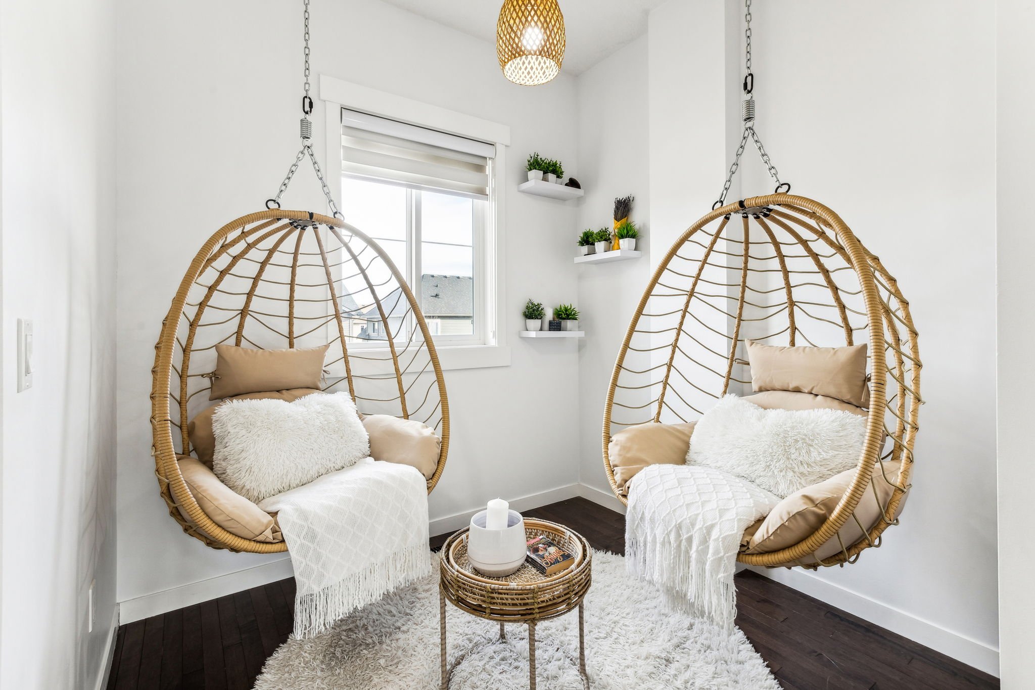 Warmly styled reading nook with egg chairs, layered textures, candles, and curated décor by Home & Harbour in Victoria BC.