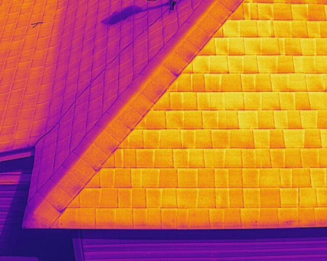 Infrared image of a building roof showing different heat signatures on various sections.