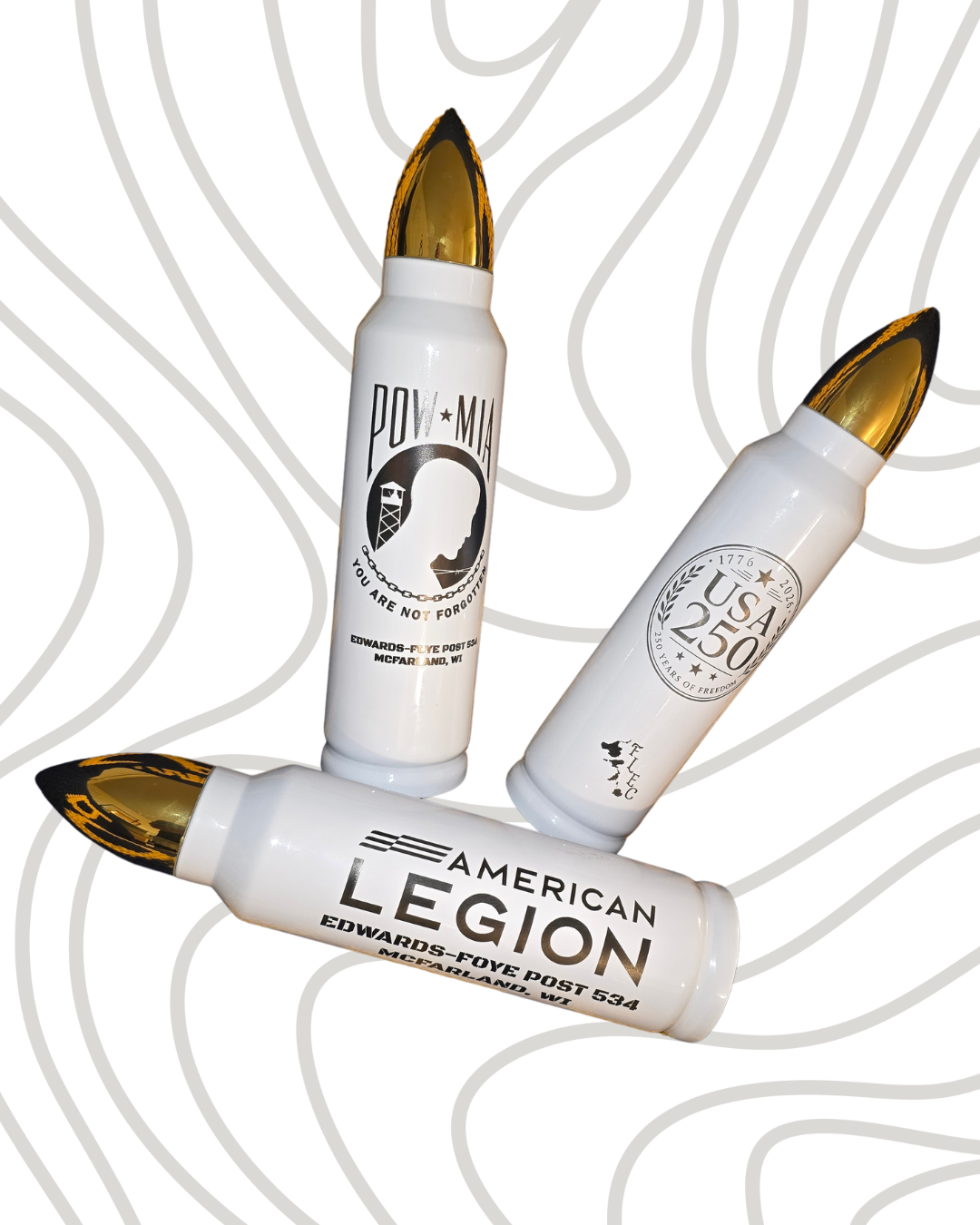 Three white bullet-shaped containers with gold and black tips, displaying patriotic and military-themed designs and text, against a light background with gray contour lines.
