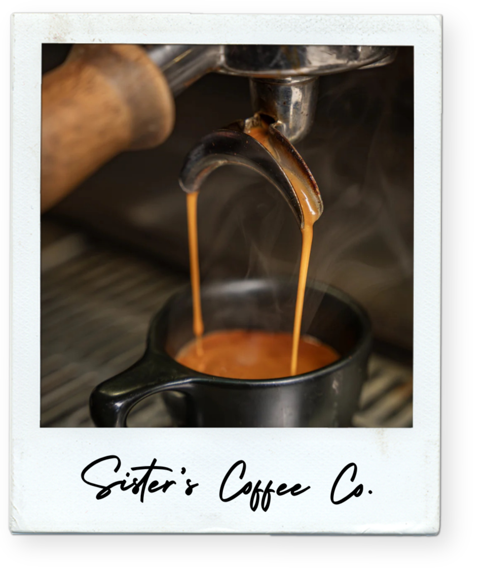 Close-up of espresso machine pouring coffee into a black cup, with steam rising, labeled 'Sister's Coffee Co.' underneath.