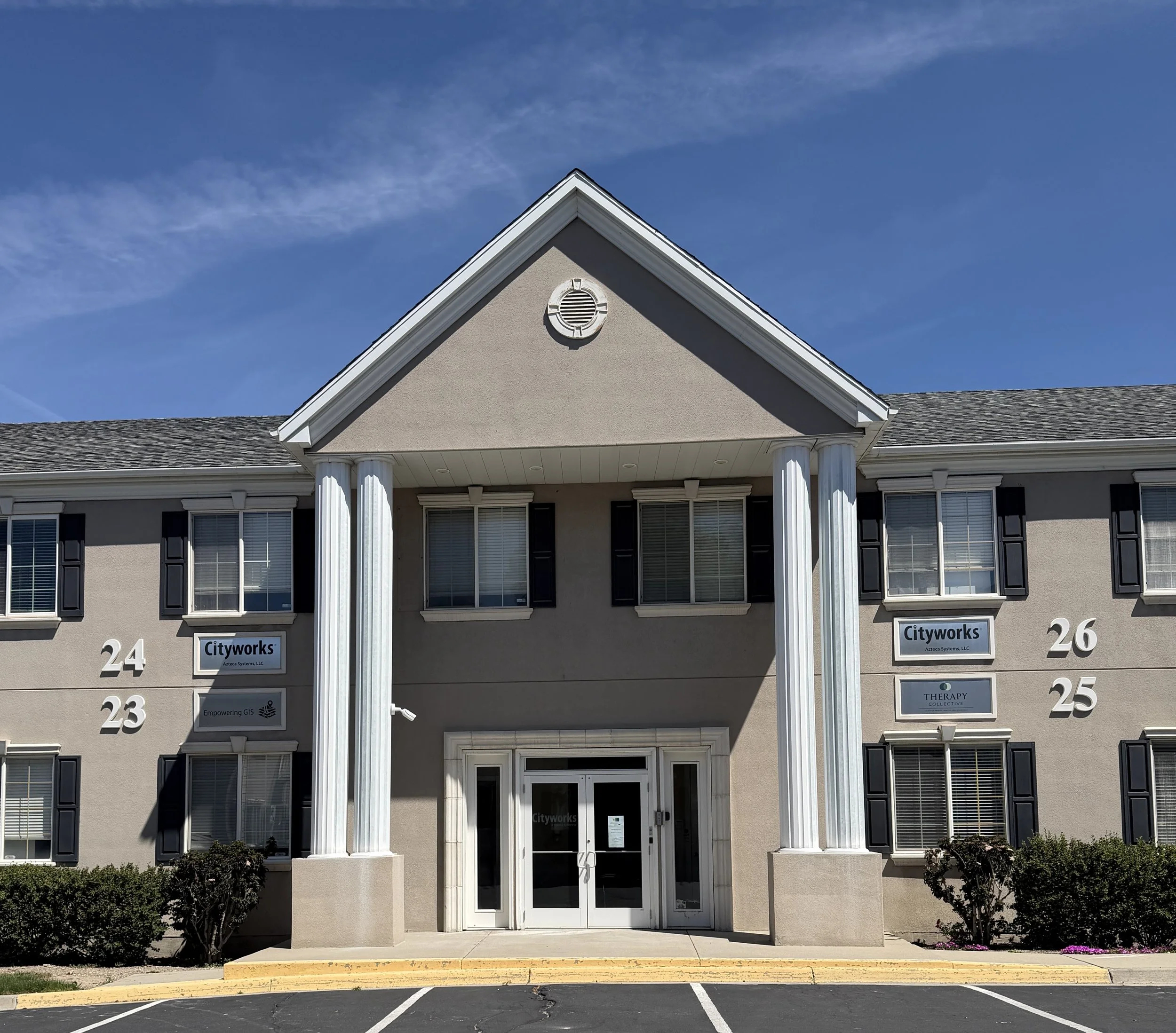 Exterior of the office building housing Willow Brook Counseling Center in Sandy, Utah, with white columns and glass entrance doors.