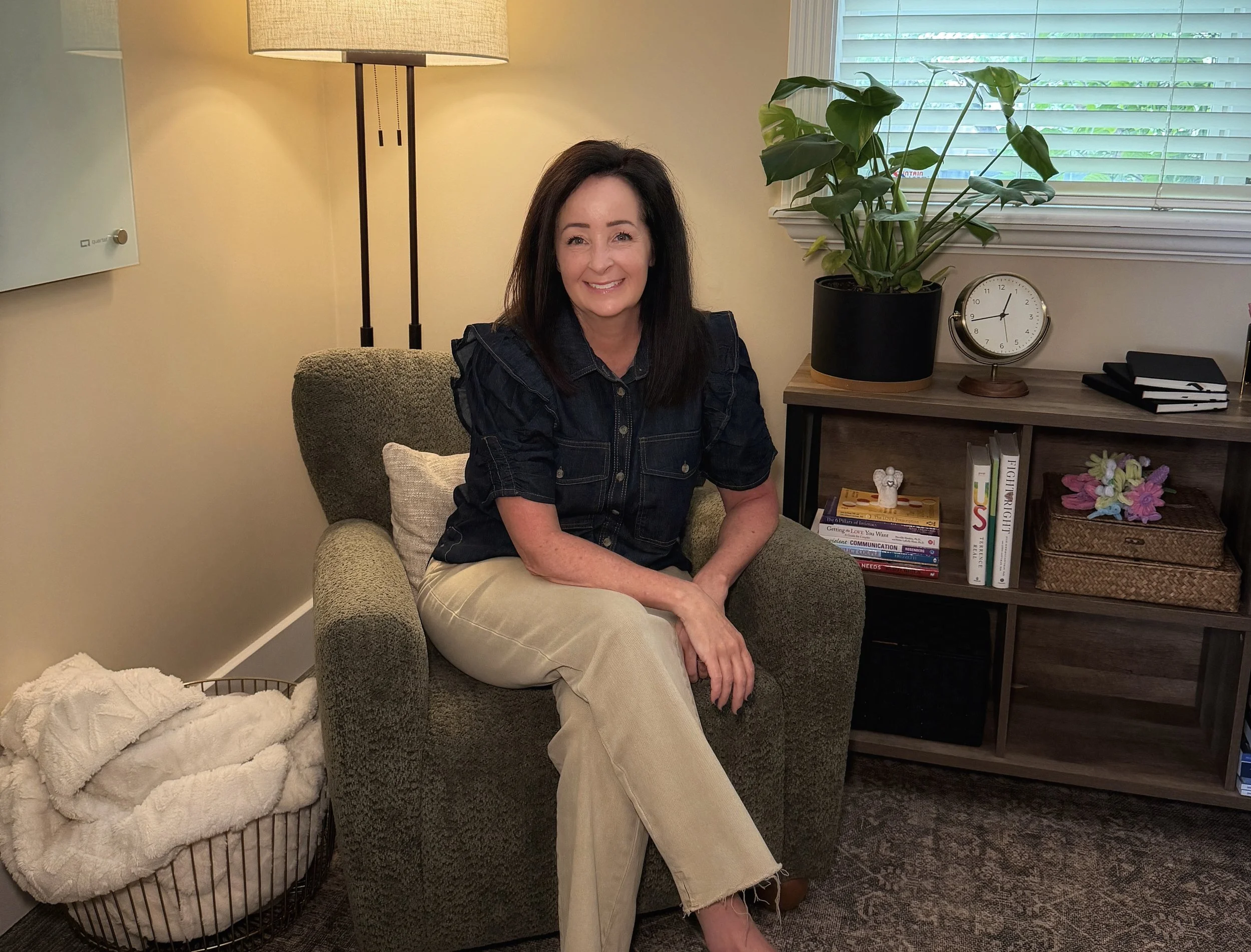 Shilea Cooper, CMHC, seated in a green armchair in the Willow Brook Counseling Center office.