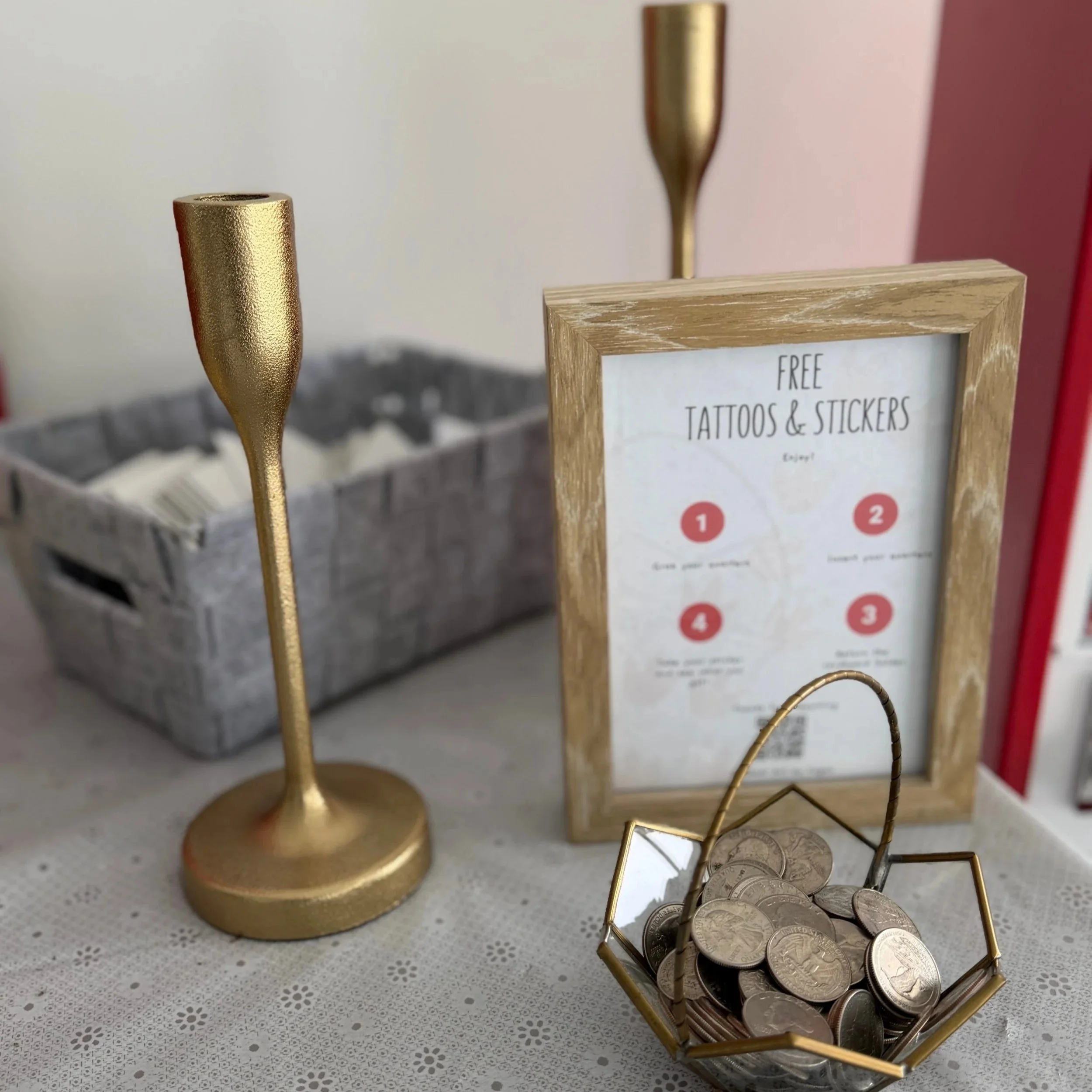 photo of a table set up with a basket, two candleabras, a frame with instructions and a little glass basket holding quarters