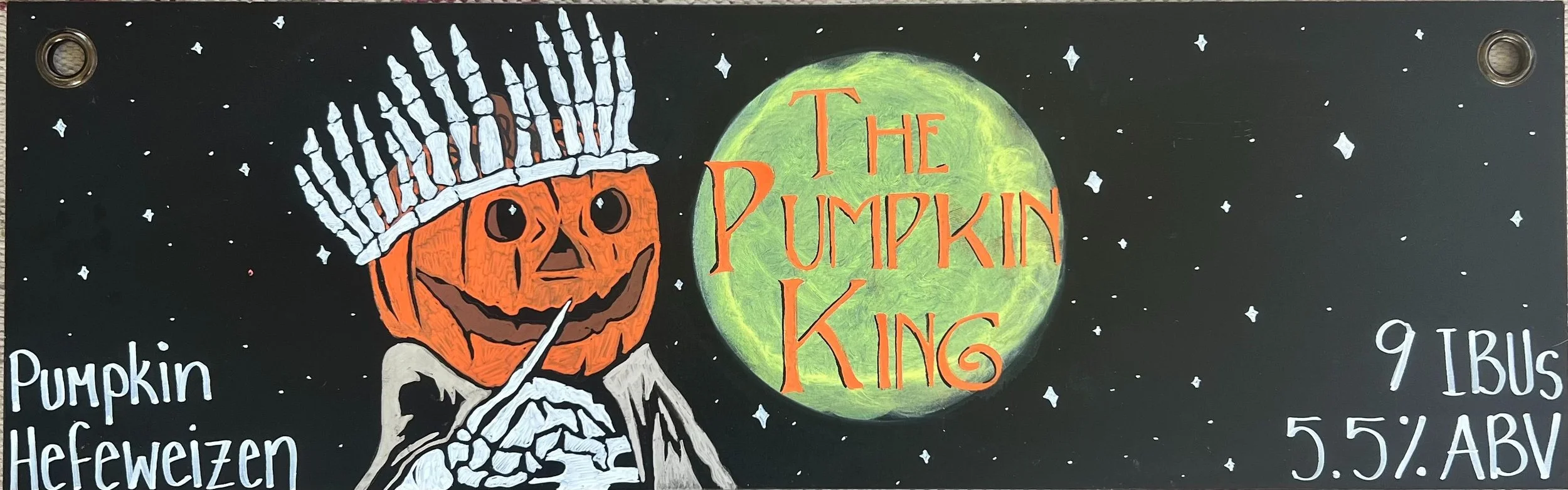 Chalk art of a pumpkin king man with a yellow moon with the words "The Pumpkin King".
