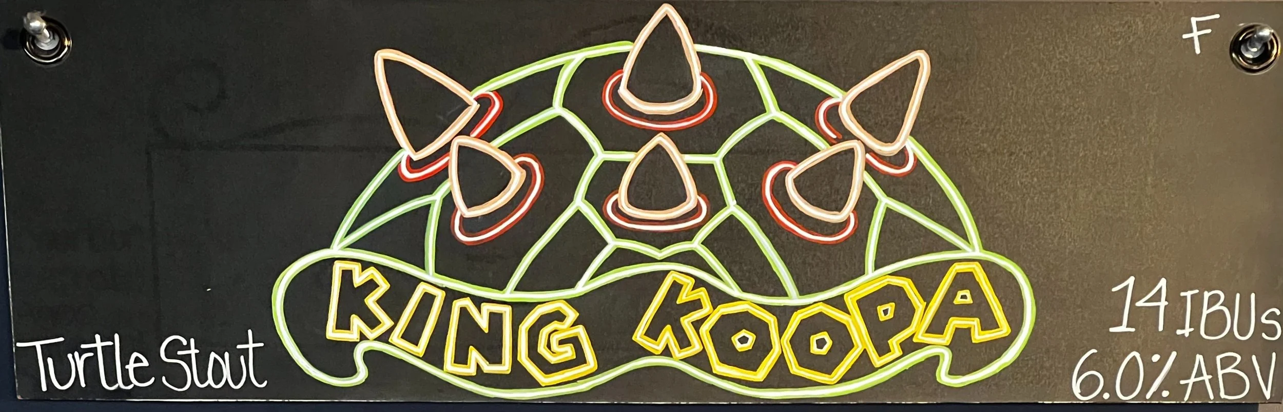 Chalk Design of King Koopa from Nintendo. Drawing of a turtle shell in neon with green and red colors. Says " King Koopa " at the bottom of the shell. Turtle Stout is the word on the bottom left.