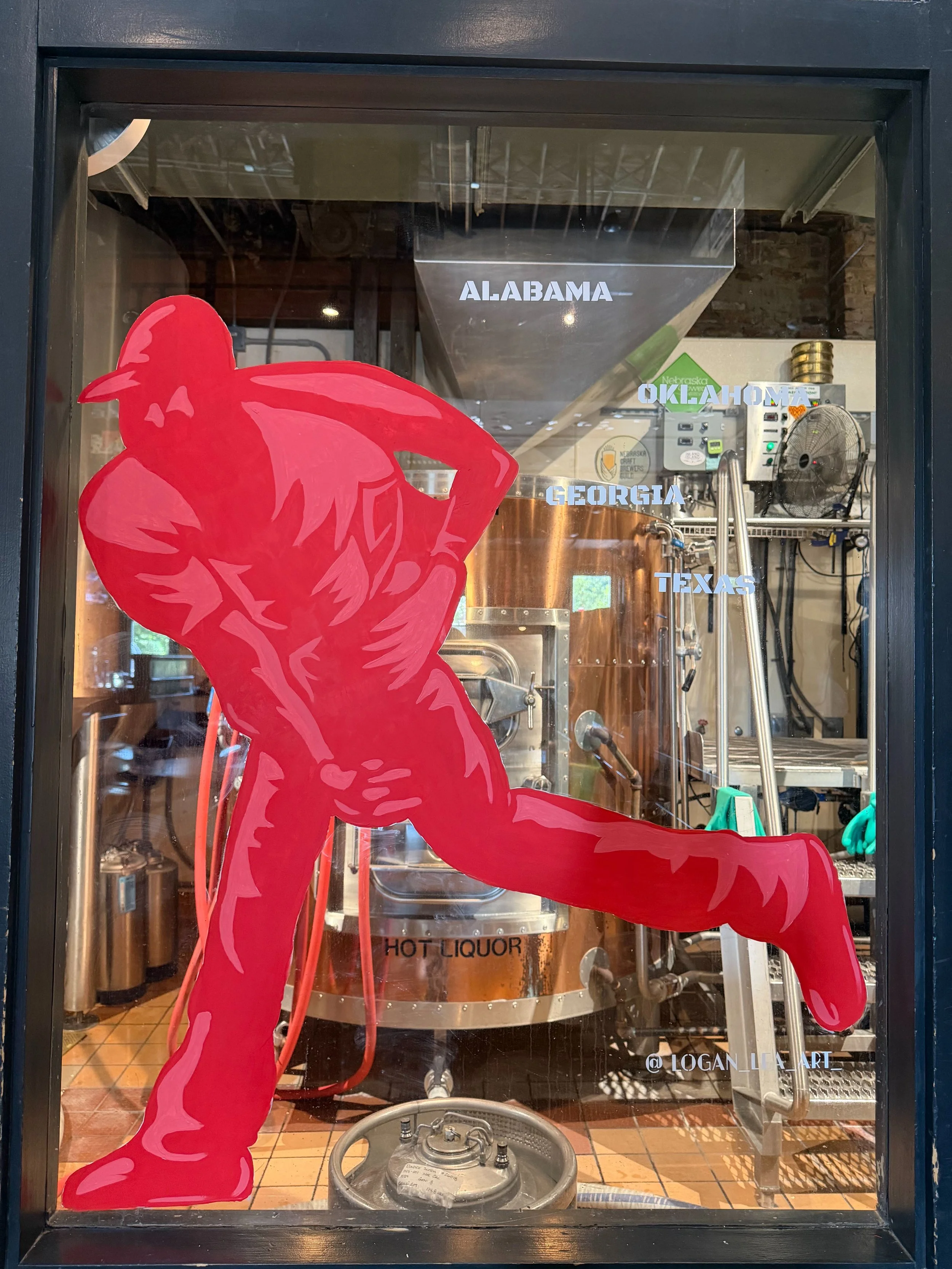 silhouette of a baseball player painted in red throwing a baseball painted on a window