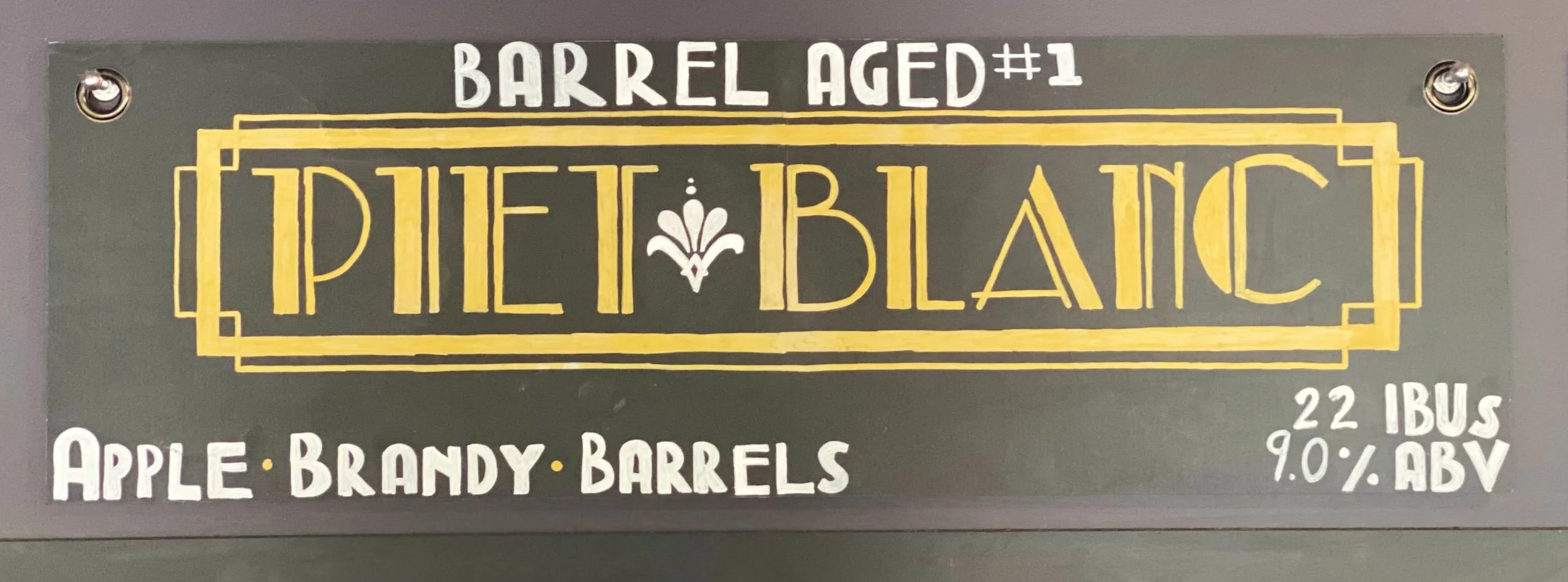 Chalk design that says Piet Blanc in a Gatsby-inspired 1920s theme. Gold lettering. Above says barrel-aged #1 and apple brandy barrels at the bottom.
