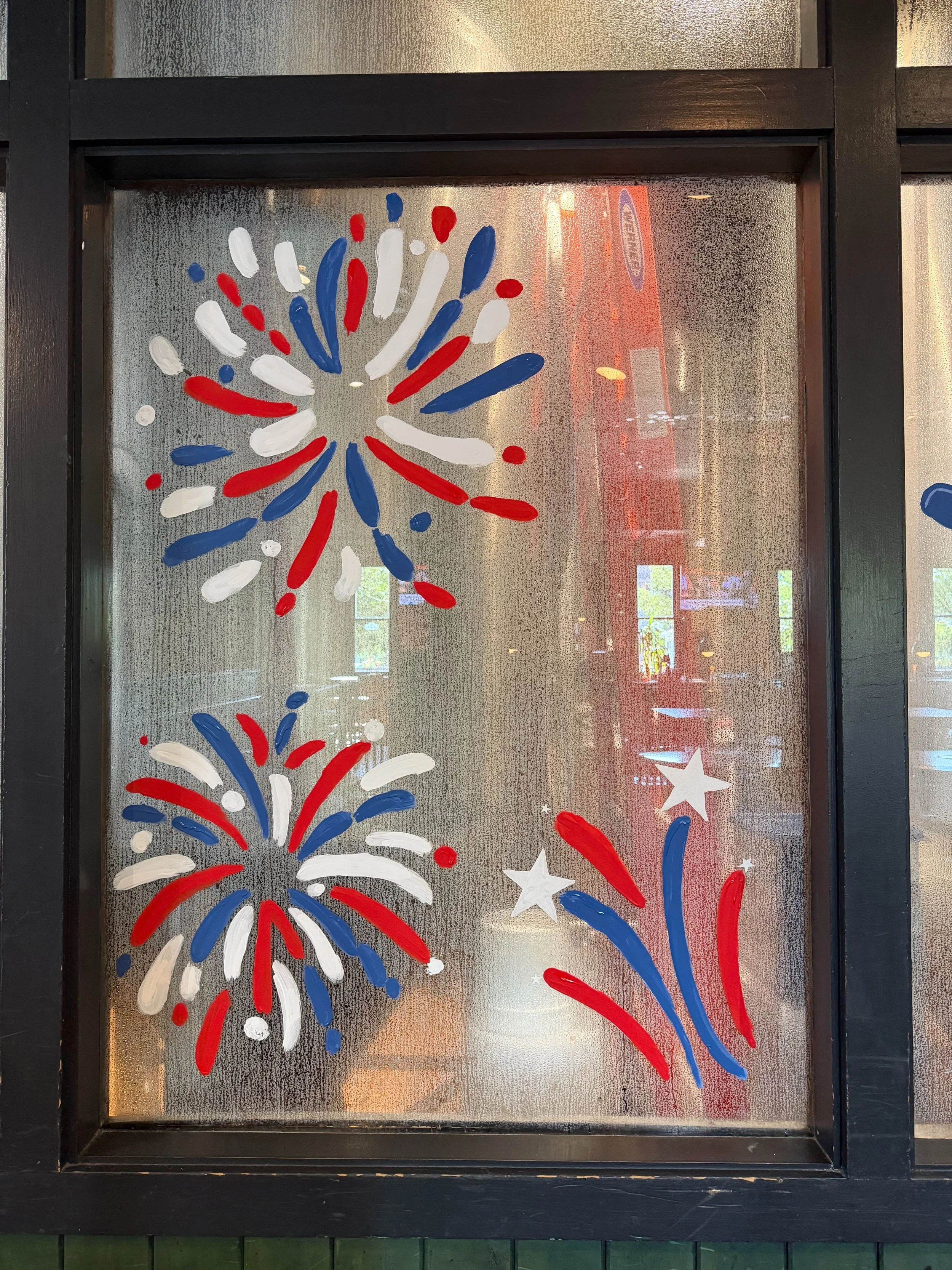 red, white, and blue fireworks painted on a window