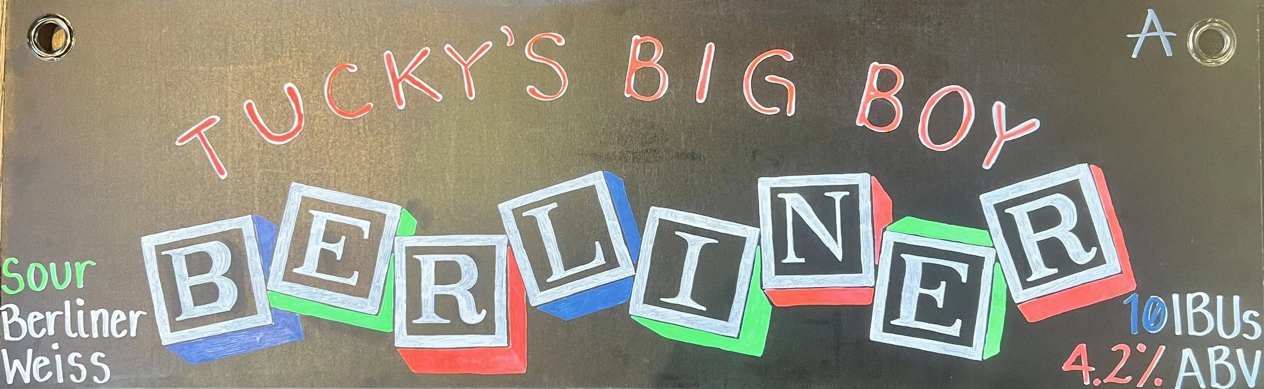 Chalk design that says Tucky's Big Boy at the top in red. Below says Berliner in children's block letter drawing. Says sour berlinerweiss on the left. 