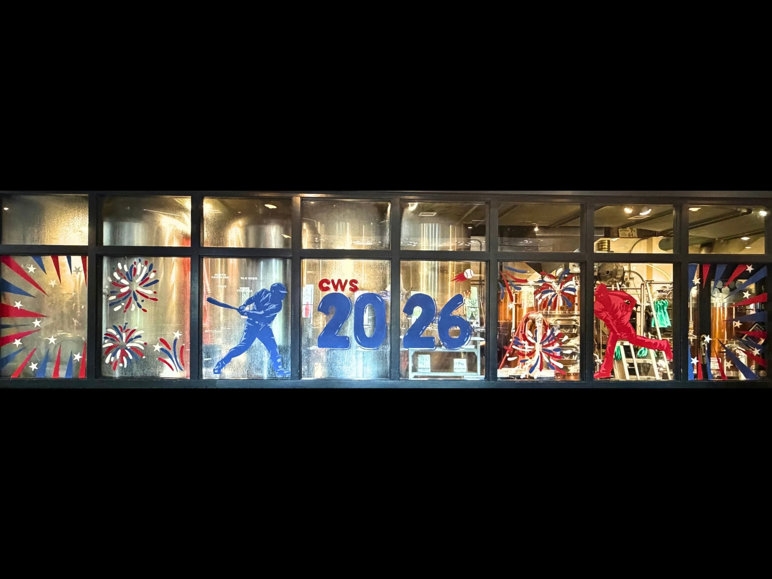 window art that says cws 2026 in the center with fireworks and two baseball players and red and white stripes.