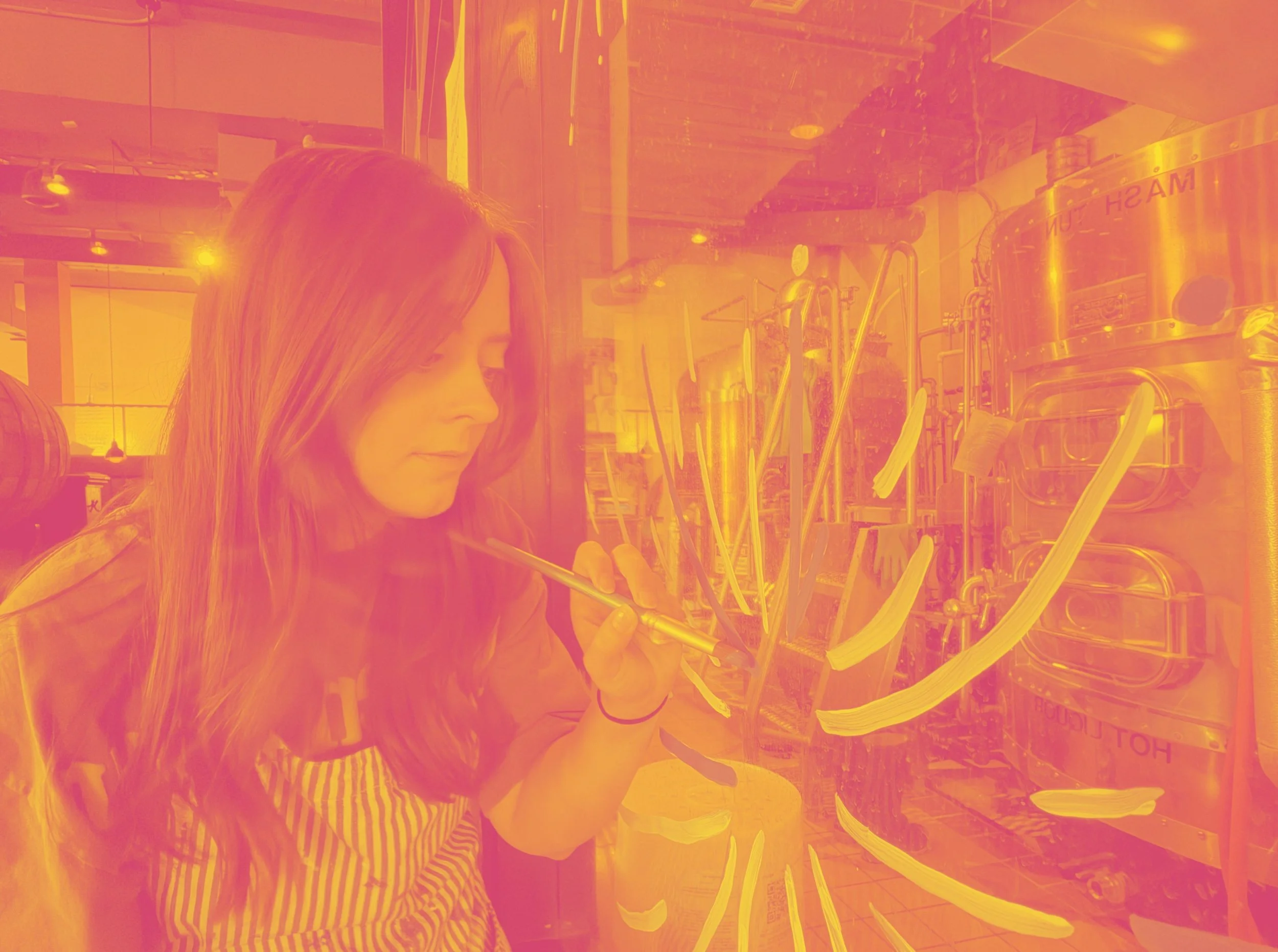 photo of woman painting on window. photo is in a pink and yellow hue