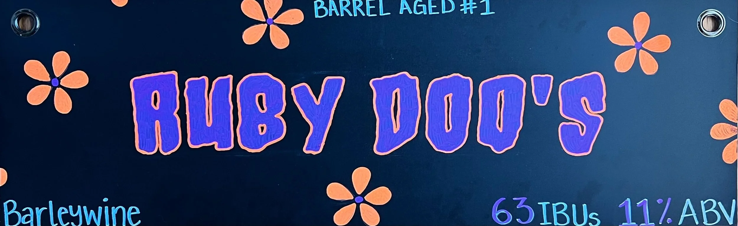 Chalk design that says Ruby Doo's inspired by Scooby Doo, with orange and purple flowers all around. Says barrel-aged #1 at the top and barleywine at the bottom.