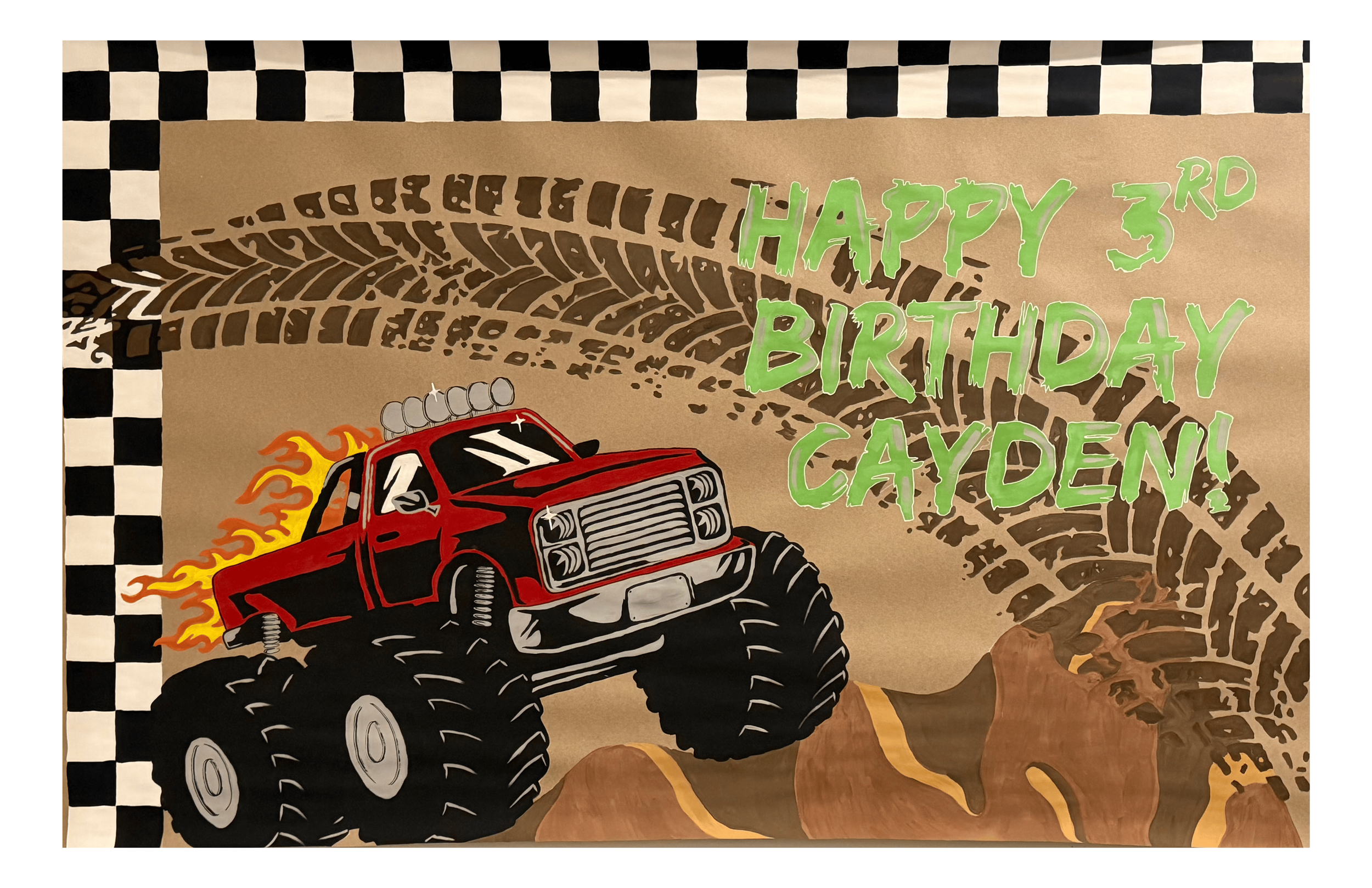 banner art on a brown craft paper. on the right says happy 3rd birthday in lime green. a brown tire mark across from left to right. the bottom left is a red monster truck with fire coming out the back driving on some brown hills toward the right. on 
