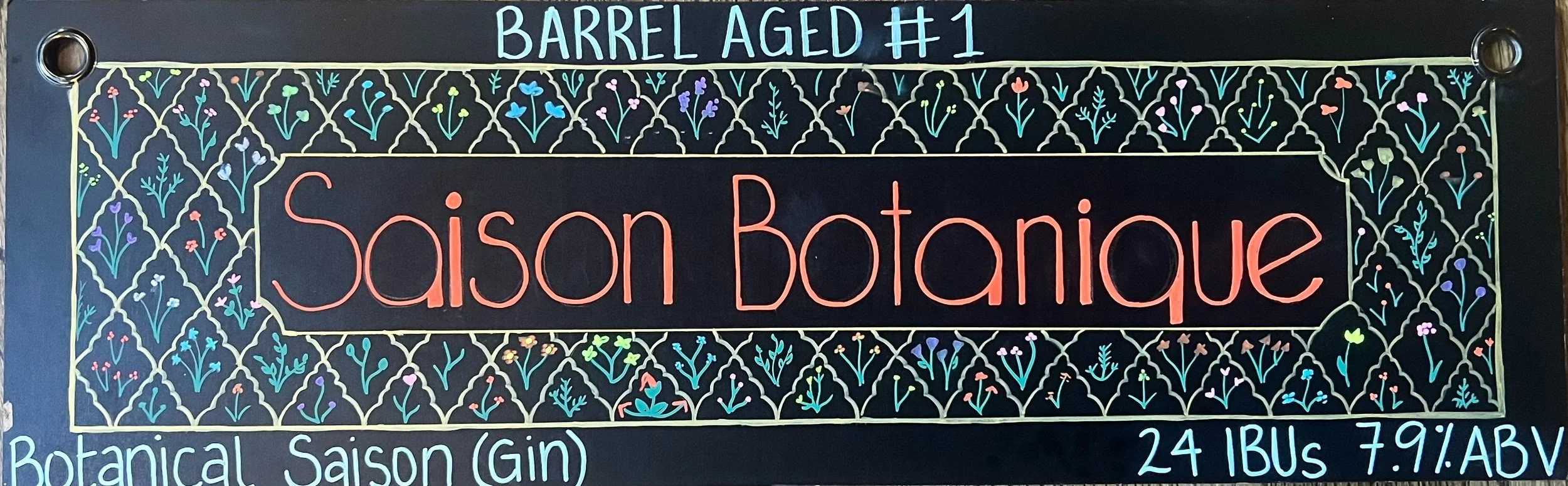 Chalk design that says Saison Botanique in red. All around are drawings of flowers in an ornate design. Barrel-aged #1 at the top. Botanical Saison (gin) at the bottom.