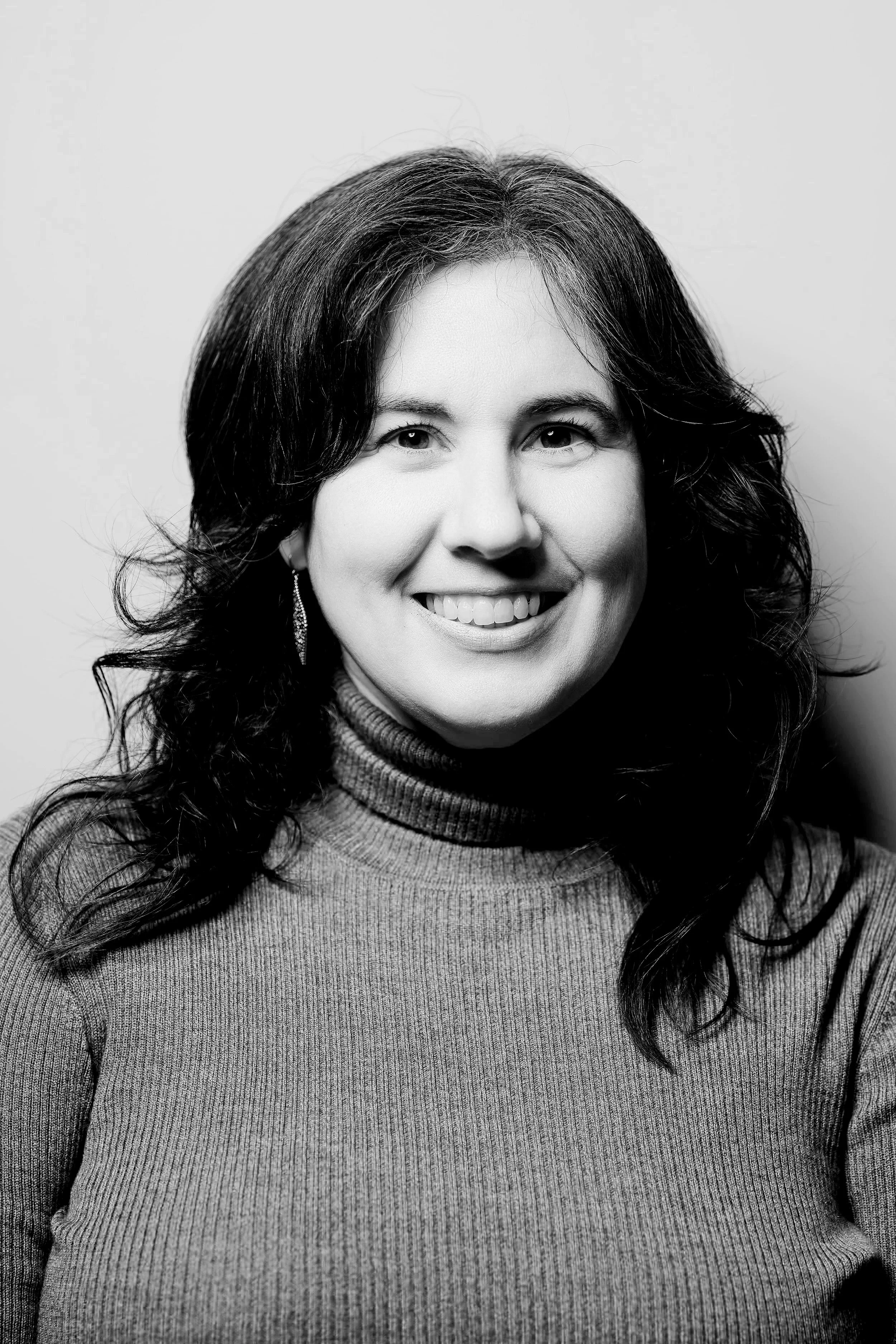 Black and white portrait of woman with curly hair wearing a turtleneck sweater