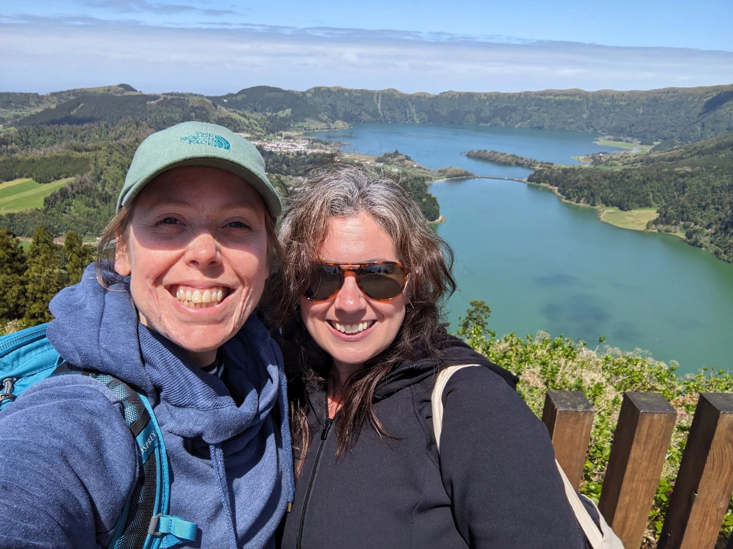 Two women smiling in a beautiful natural landscape.