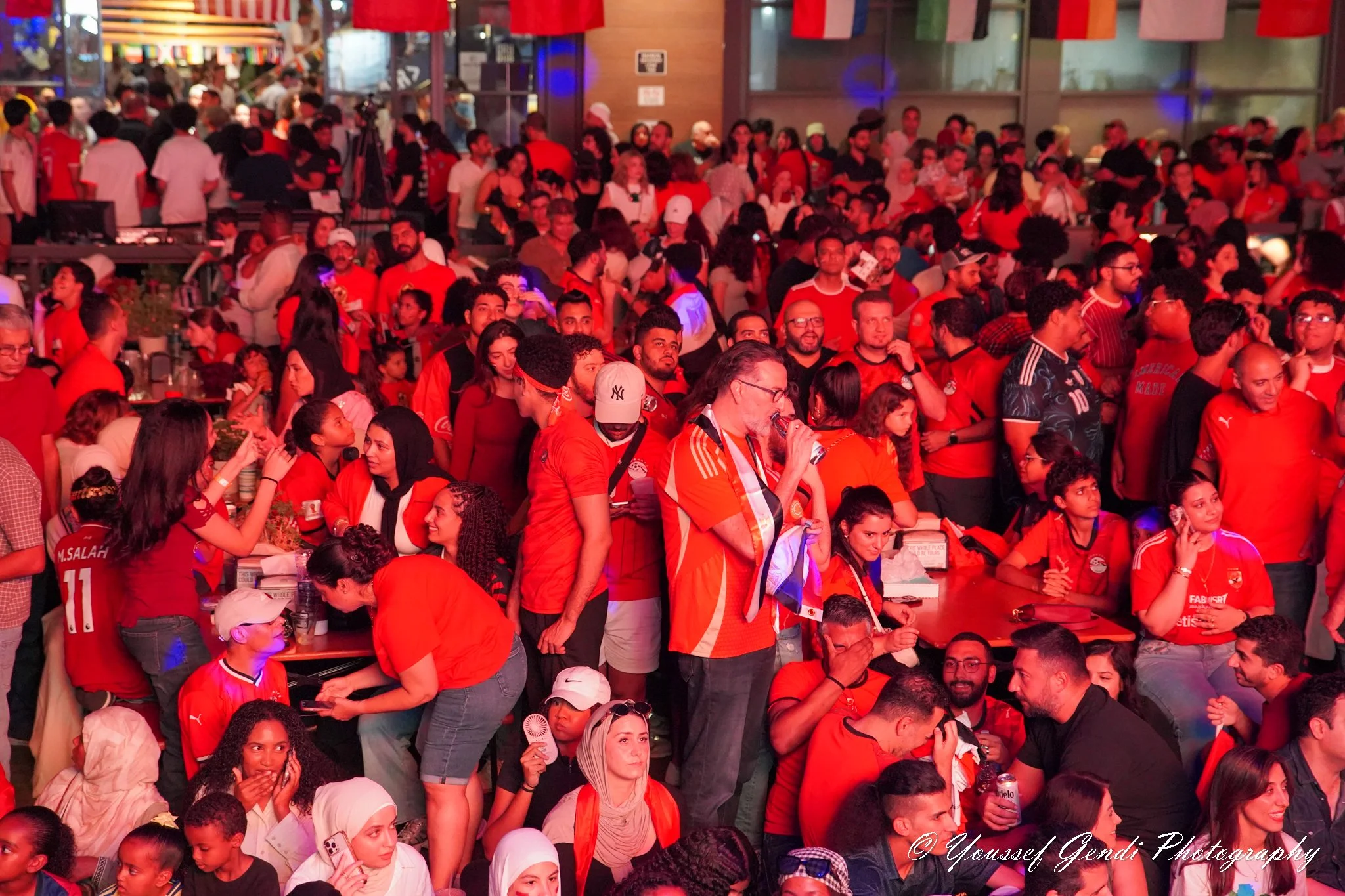 Egyptian soccer fans gathering at Legacy Hall in Dallas, Texas, celebrating Egypt and cheering together during an Egypt DFW World Cup community event in Dallas–Fort Worth.