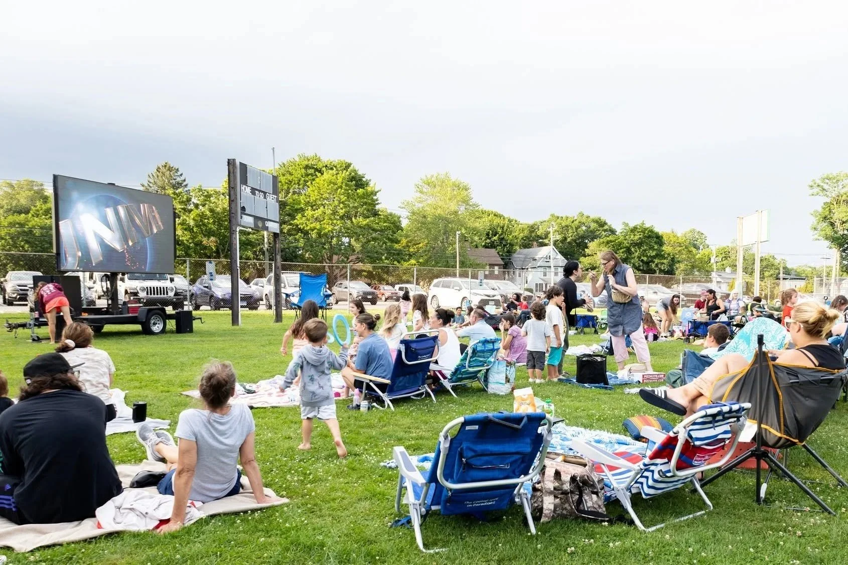 Families enjoying an outdoor movie night on blankets at Wason Field, Downtown Milford, CT
