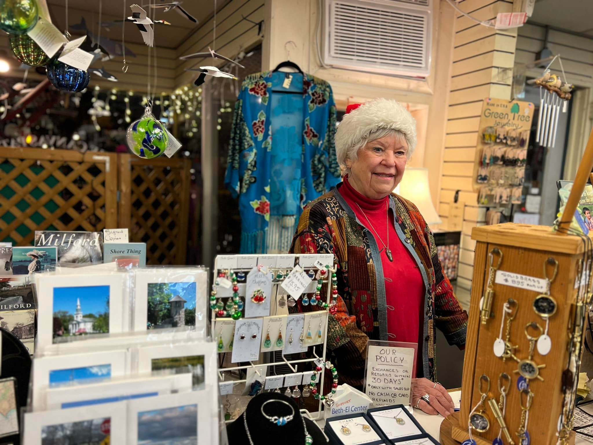 Patch Canvas owner smiling and welcoming shoppers at the annual Downtown Milford Christmas market, Lamplight Stroll organized by the Downtown Milford Business Association. 