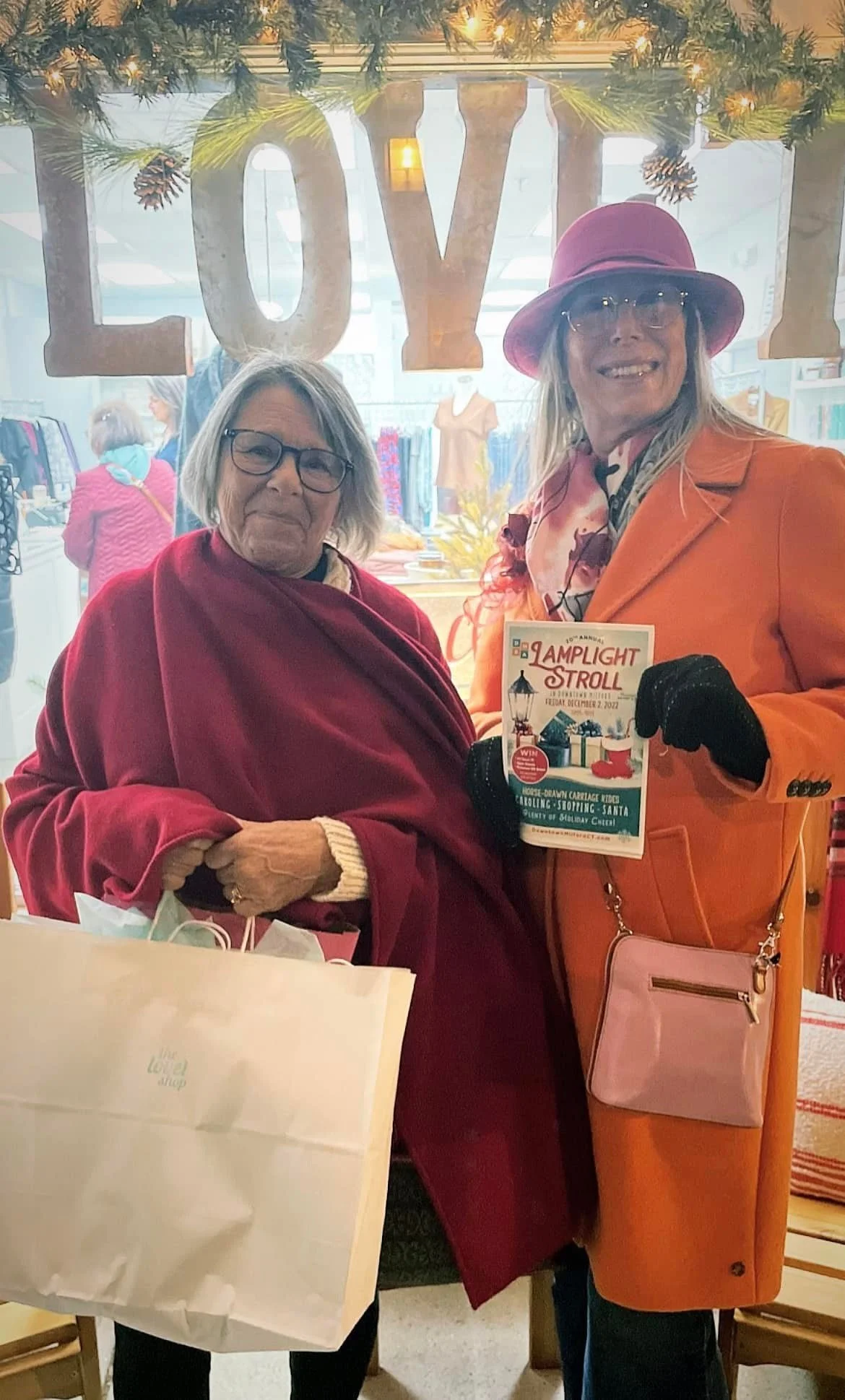 Holiday shoppers exploring local vendors and festive displays at the Downtown Milford Lamplight Stroll with the Stroll Passport.