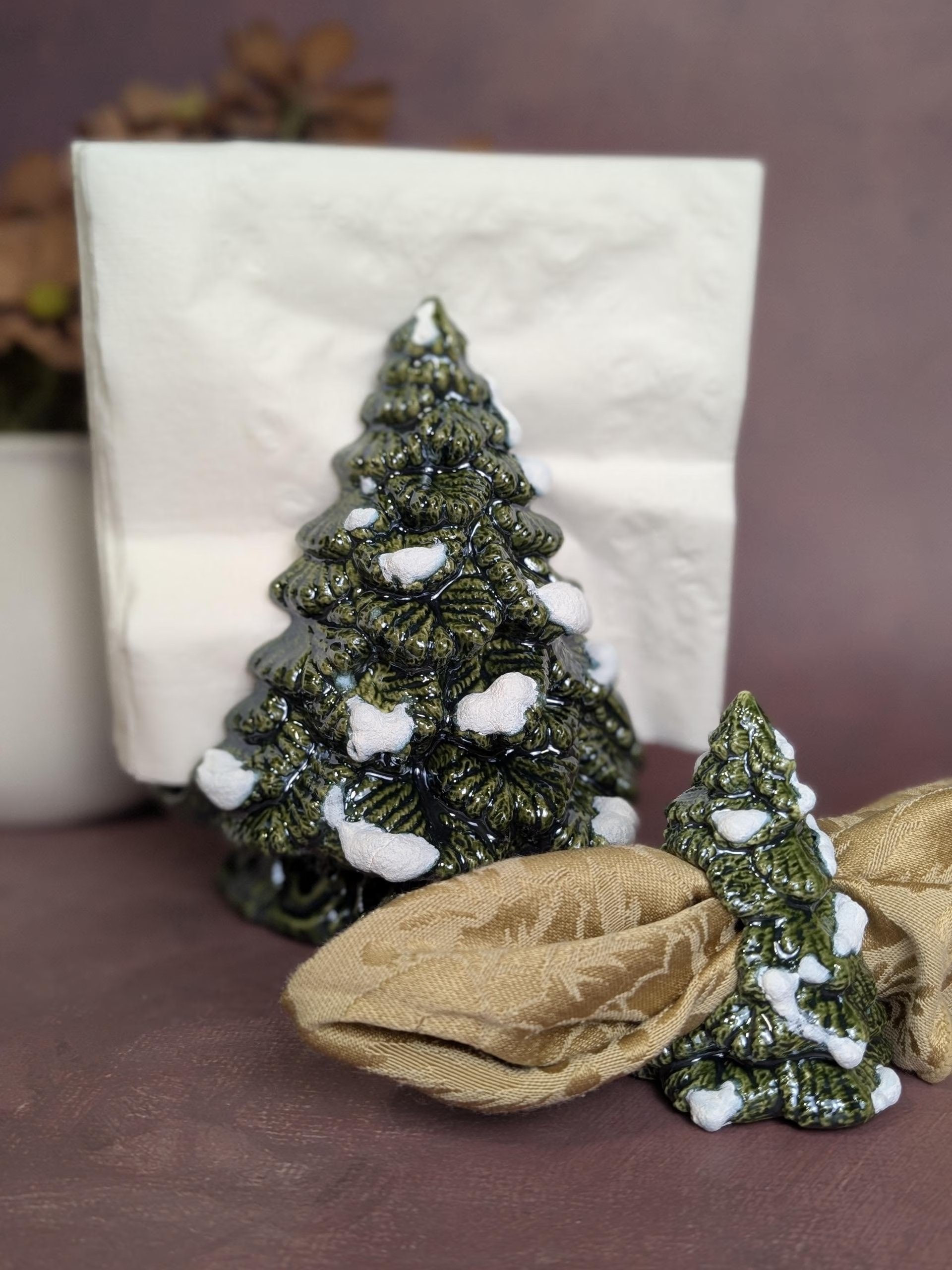 Matching Christmas tree napkin holder and rings in a classic green glaze with fired snow accents 