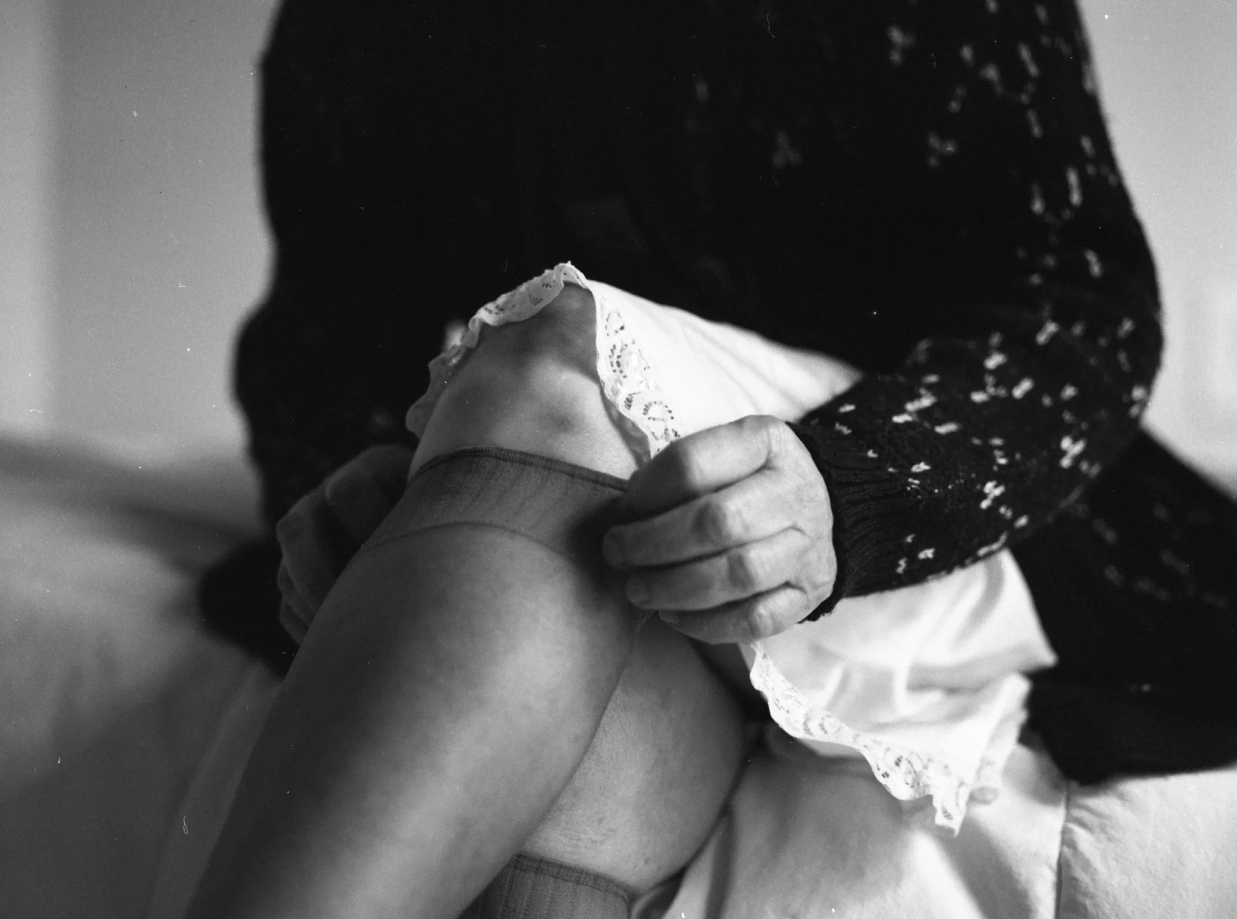Close-up of a person holding a small child, focusing on the child's head and part of their body. The image is black and white.