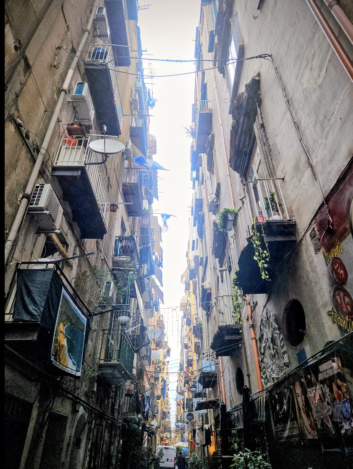 This narrow alleyway in Italy was alive with ordinary people going about their day, a reminder that beauty is often found in life's simplest moments.