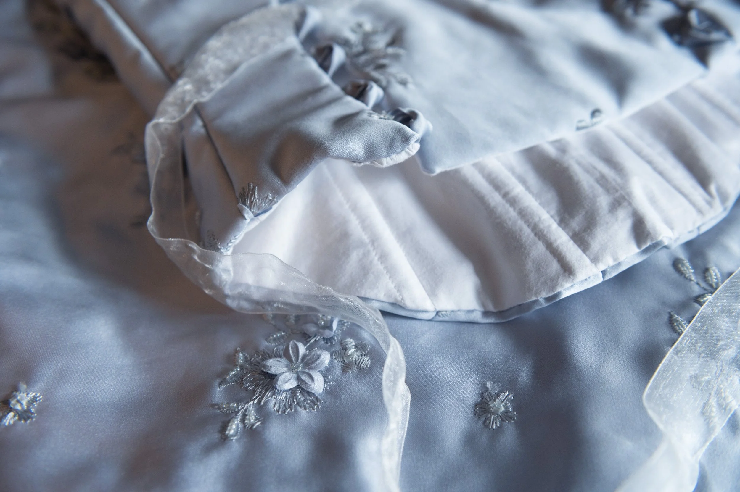 Close-up of a pale blue corset and skirt set with embroidered floral details.