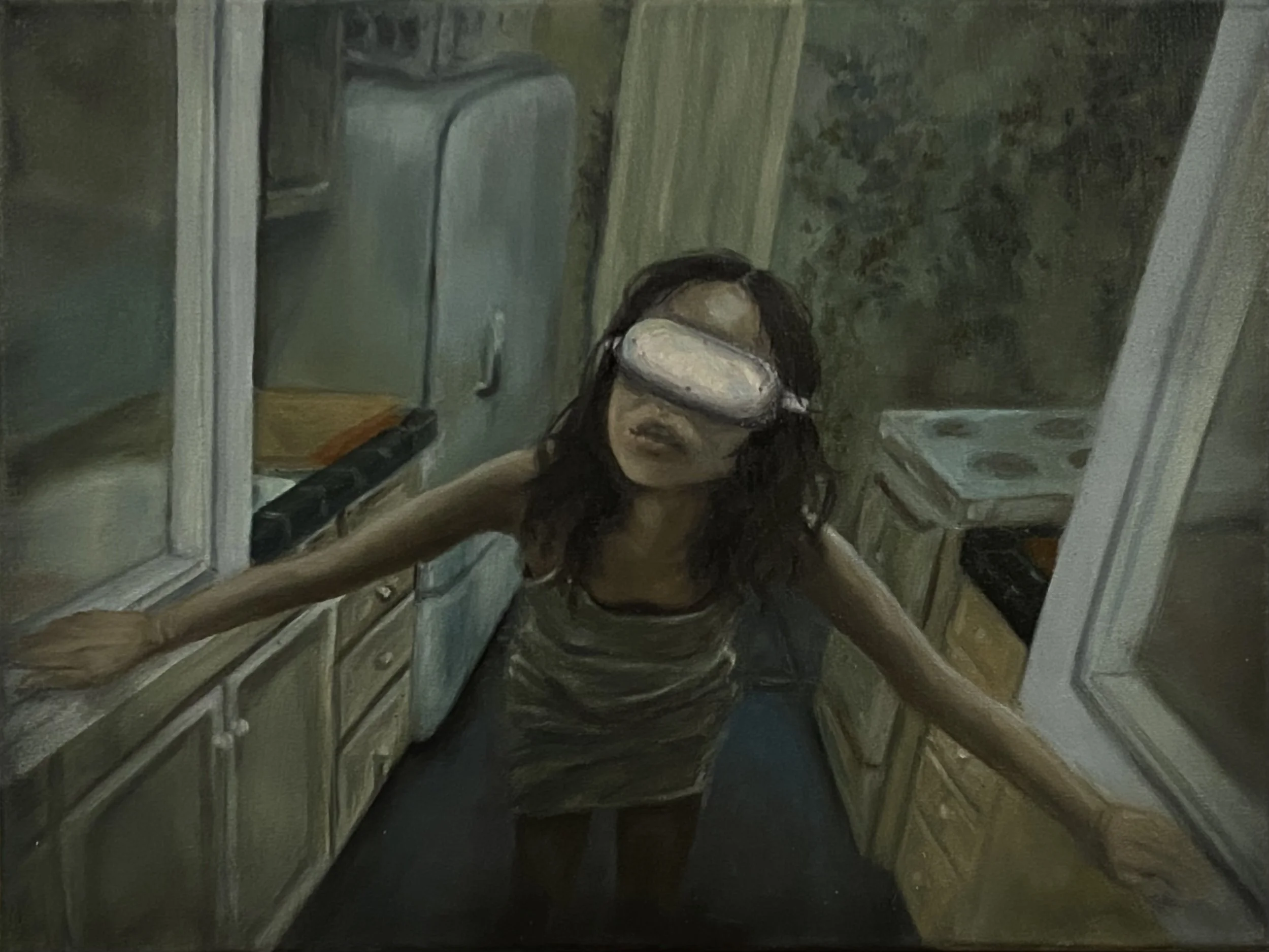 A woman with dark hair wearing white VR headset. She is standing in the kitchen looking out the window.