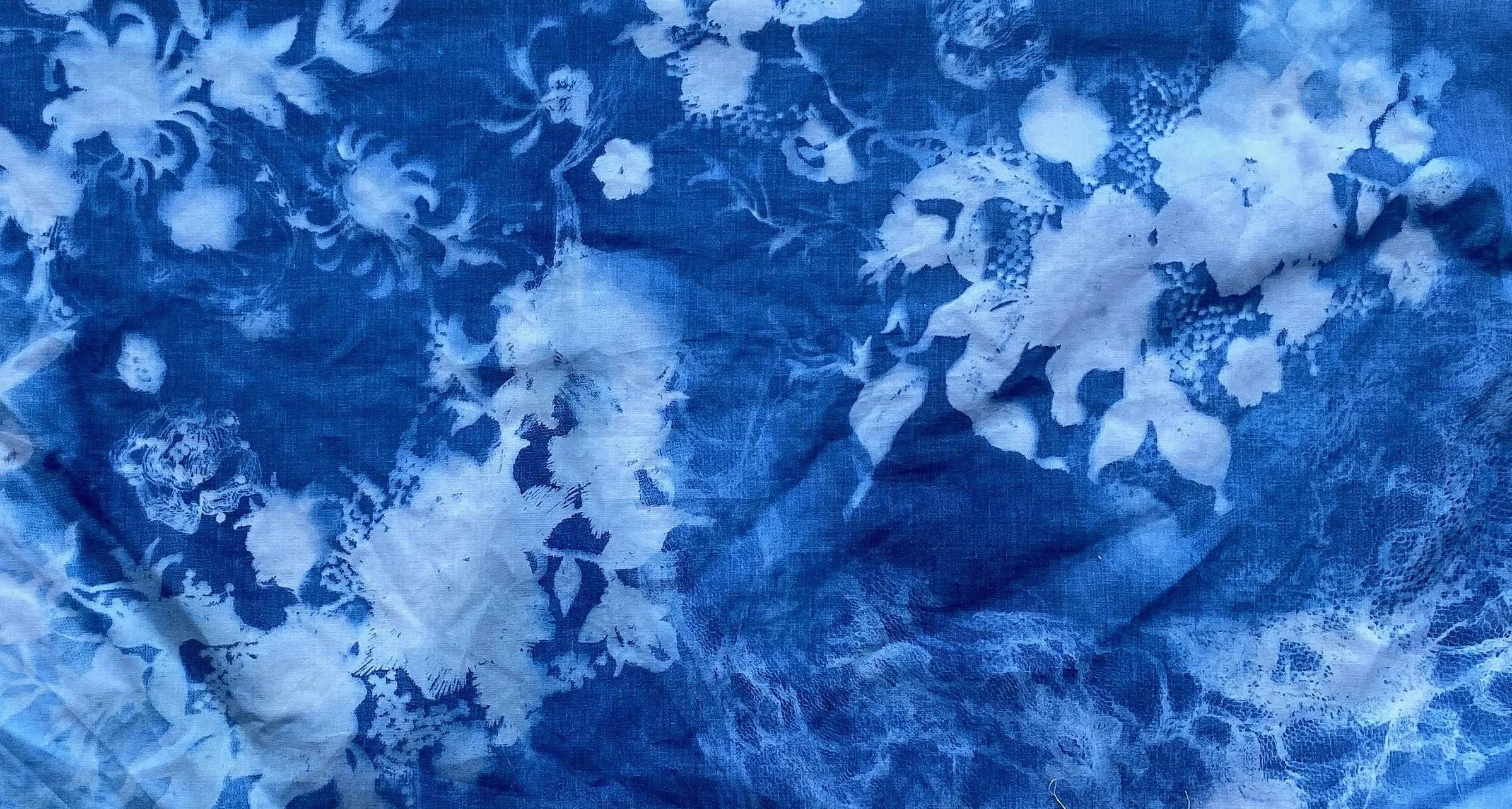 A piece of fabric with a floral pattern in white and blue colors.