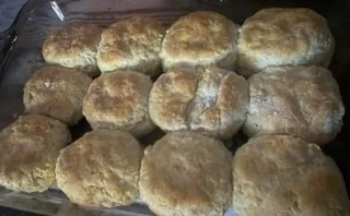 Several homemade bread rolls on a baking sheet.
