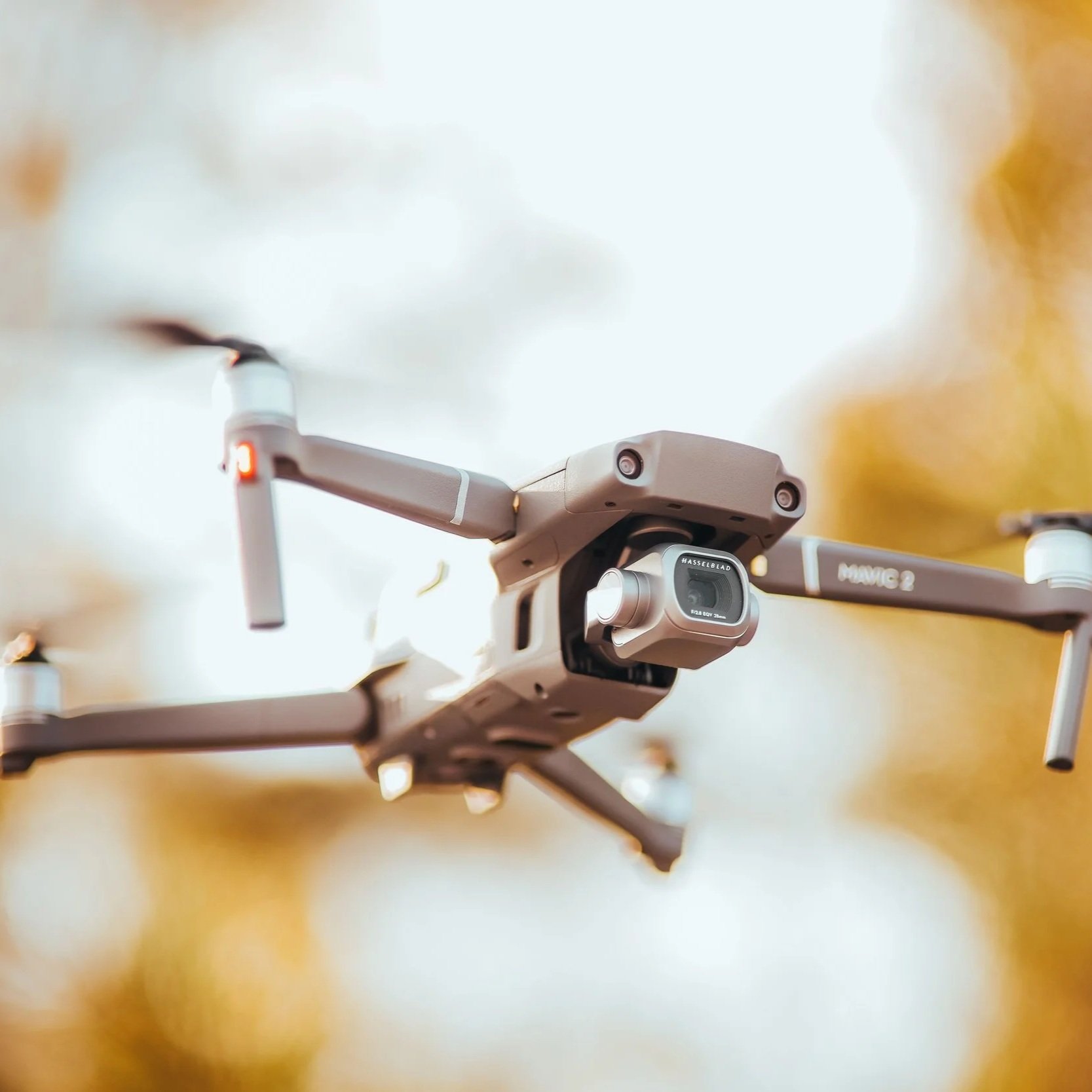 Close-up of a drone with a camera mounted on the front, set against a background of a wooden surface.