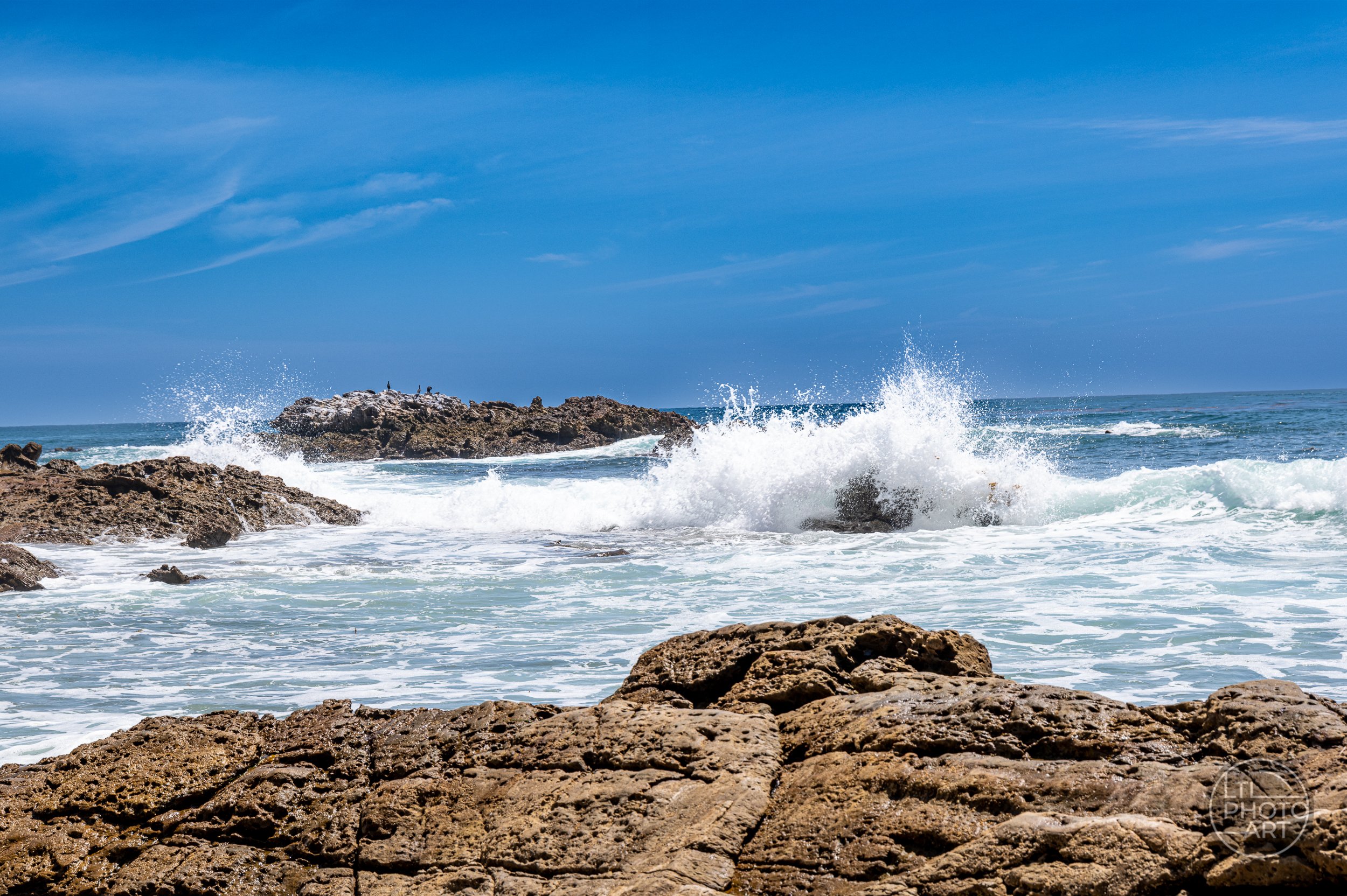 Waves crashing over coastal rocks near Bird Rock in Laguna Beach, California.