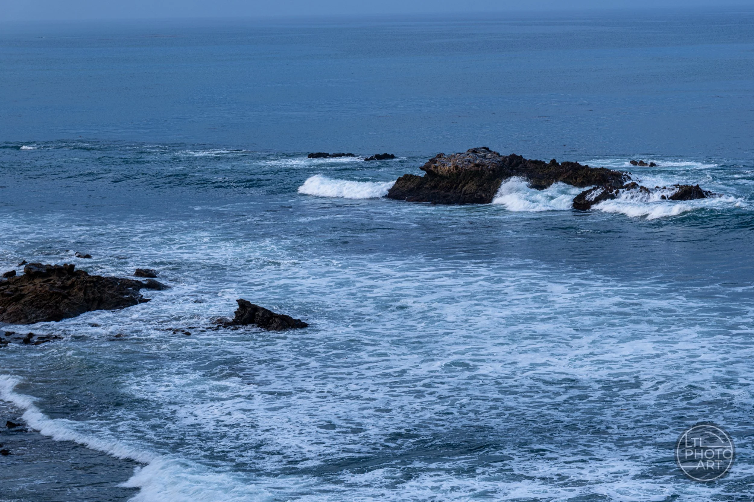 Slow-shutter photograph of waves flowing around Bird Rock in Laguna Beach, California.