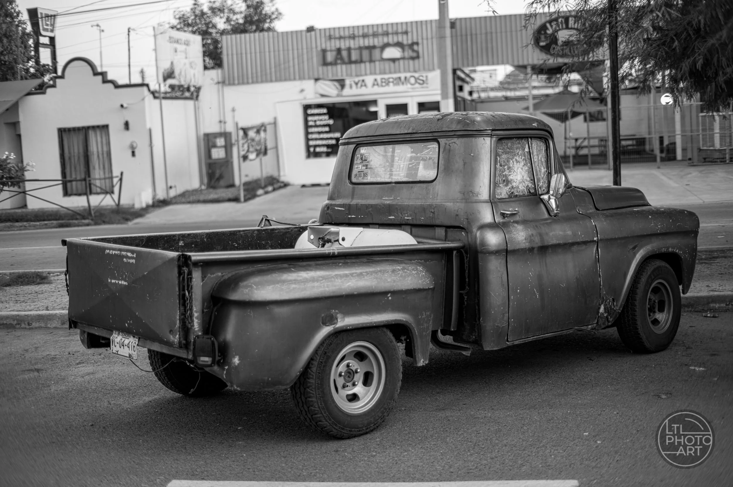 A weathered pickup truck rests along a neighborhood street during a food stop in Hermosillo, Mexico.