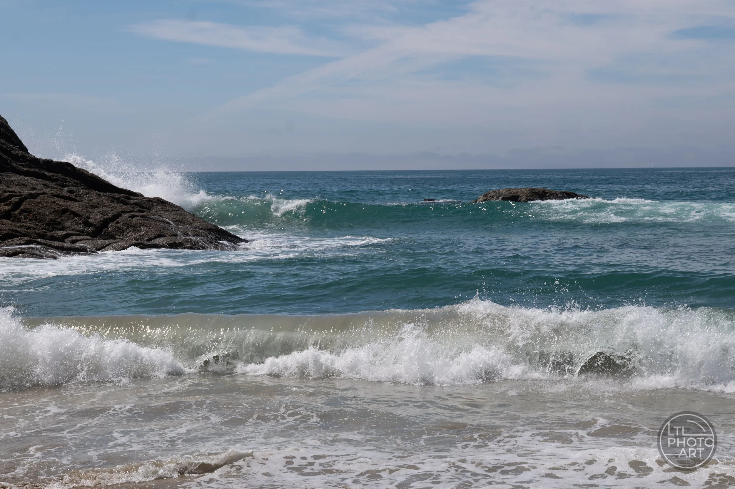 Breaking waves and dark coastal rocks near the blowhole at Strands Beach in Dana Point, California.