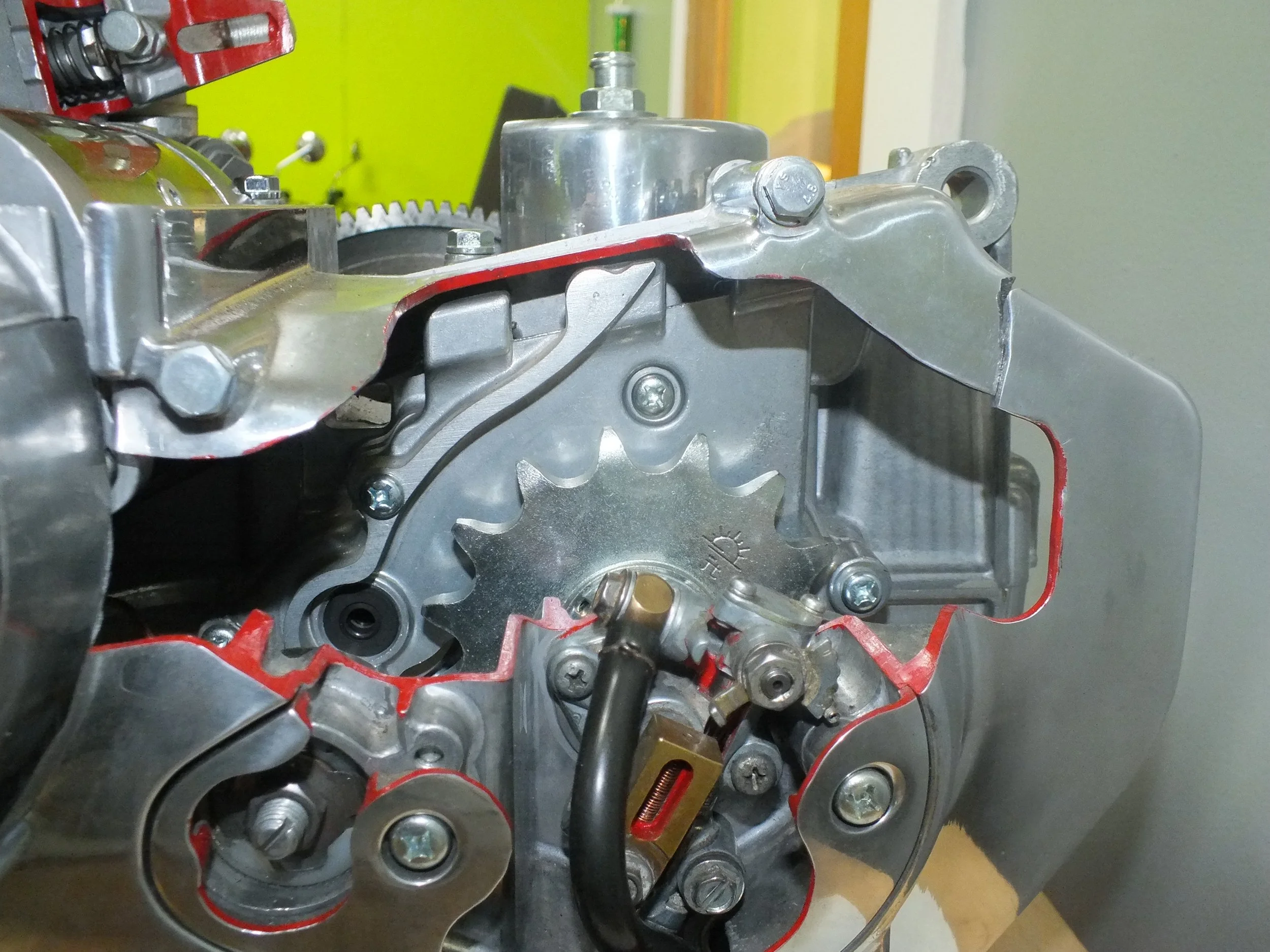 Close-up of mechanical engine components with visible gears, bolts, and parts of metal engine housing.