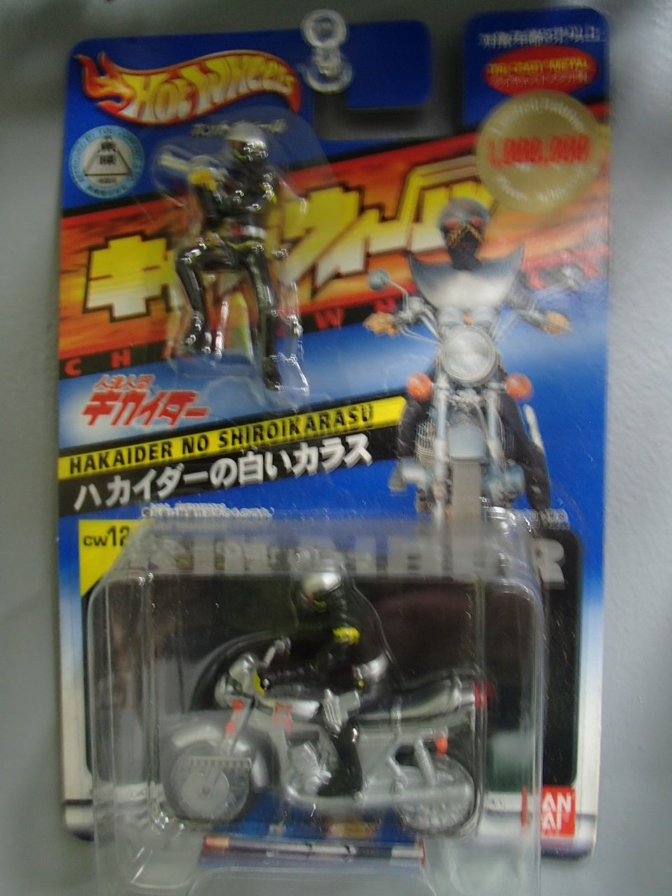 A Hot Wheels toy motorcycle with a Darth Vader figure on it, attached to packaging with Japanese text and images of a motorcycle and a figure in a helmet.