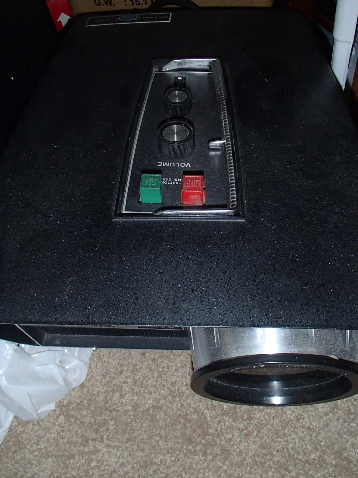 Close-up of a black commercial kitchen stove with two control knobs and two utility switches on a black countertop.