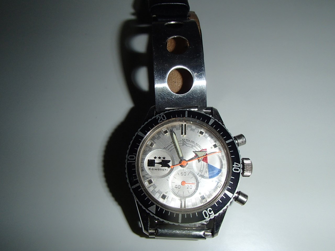 A wristwatch with a metal band displaying multiple dials and a tachymeter bezel.
