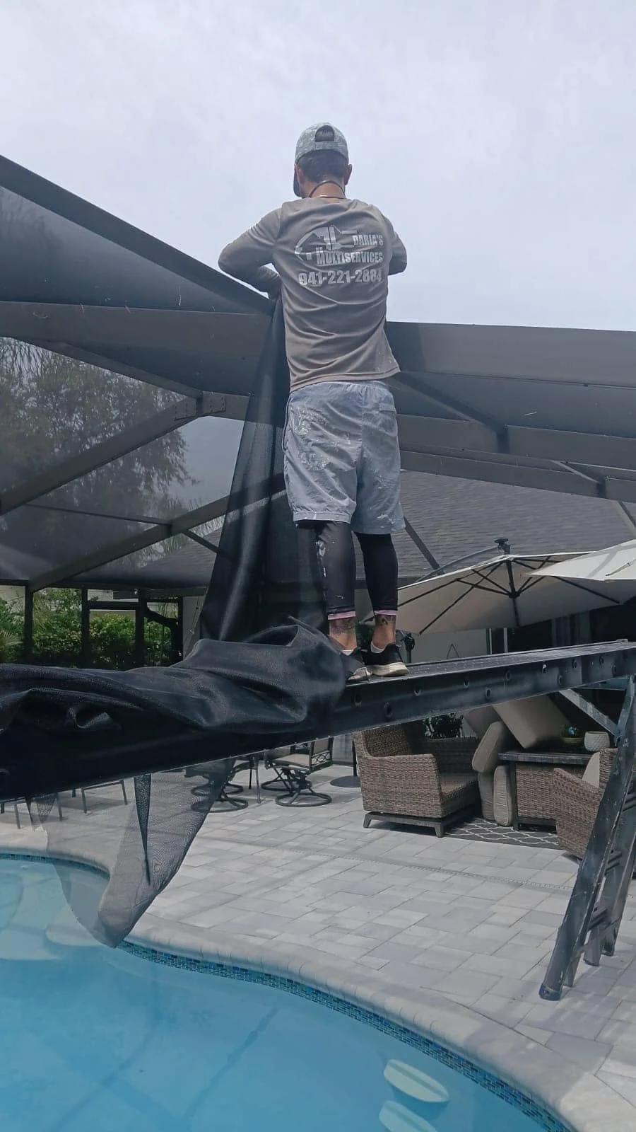 Daria’s Multiservices technician installing screen during a professional pool cage restoration project in Florida.