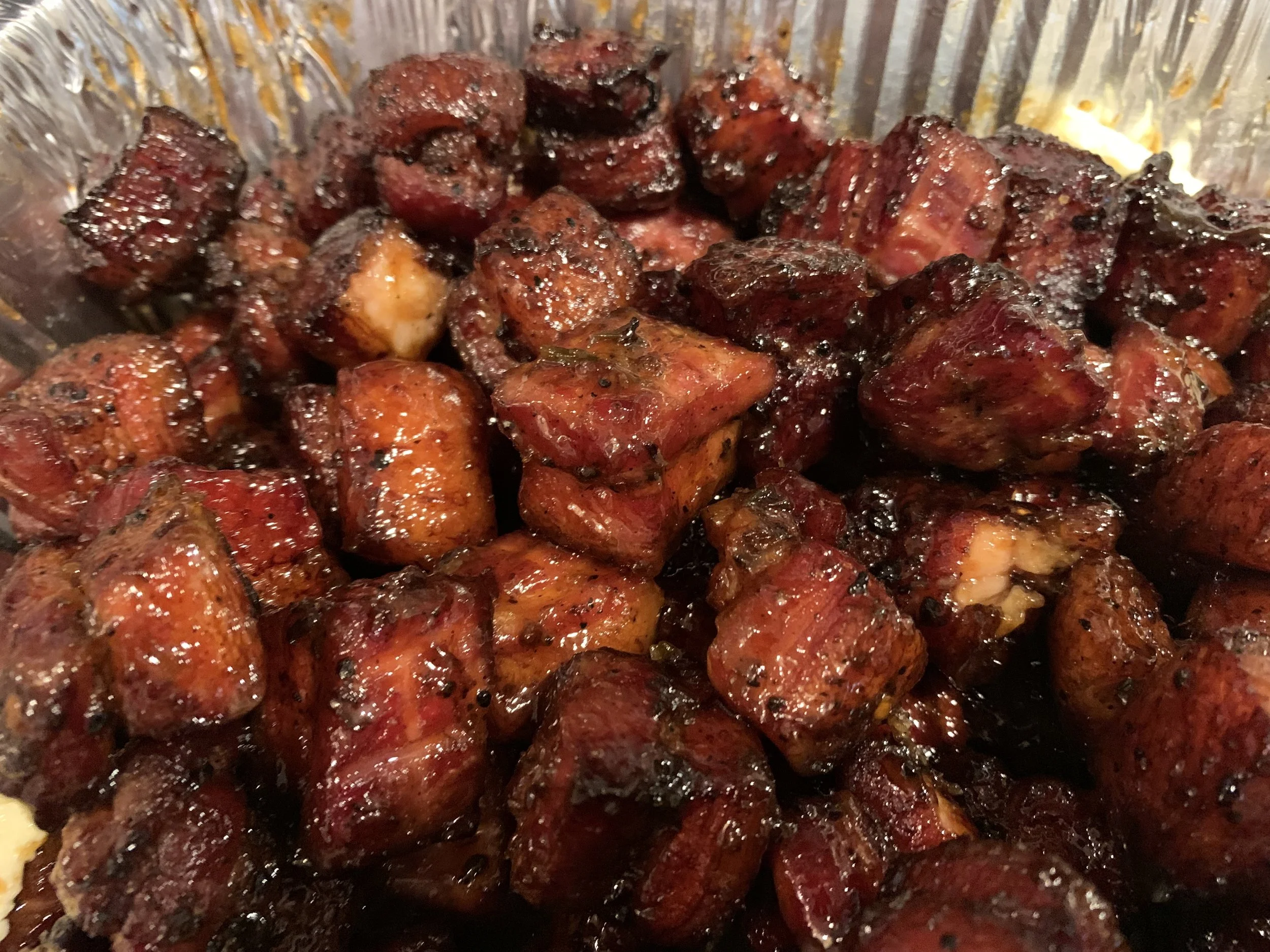 Close-up of cooked sausage chunks with a dark, glossy exterior