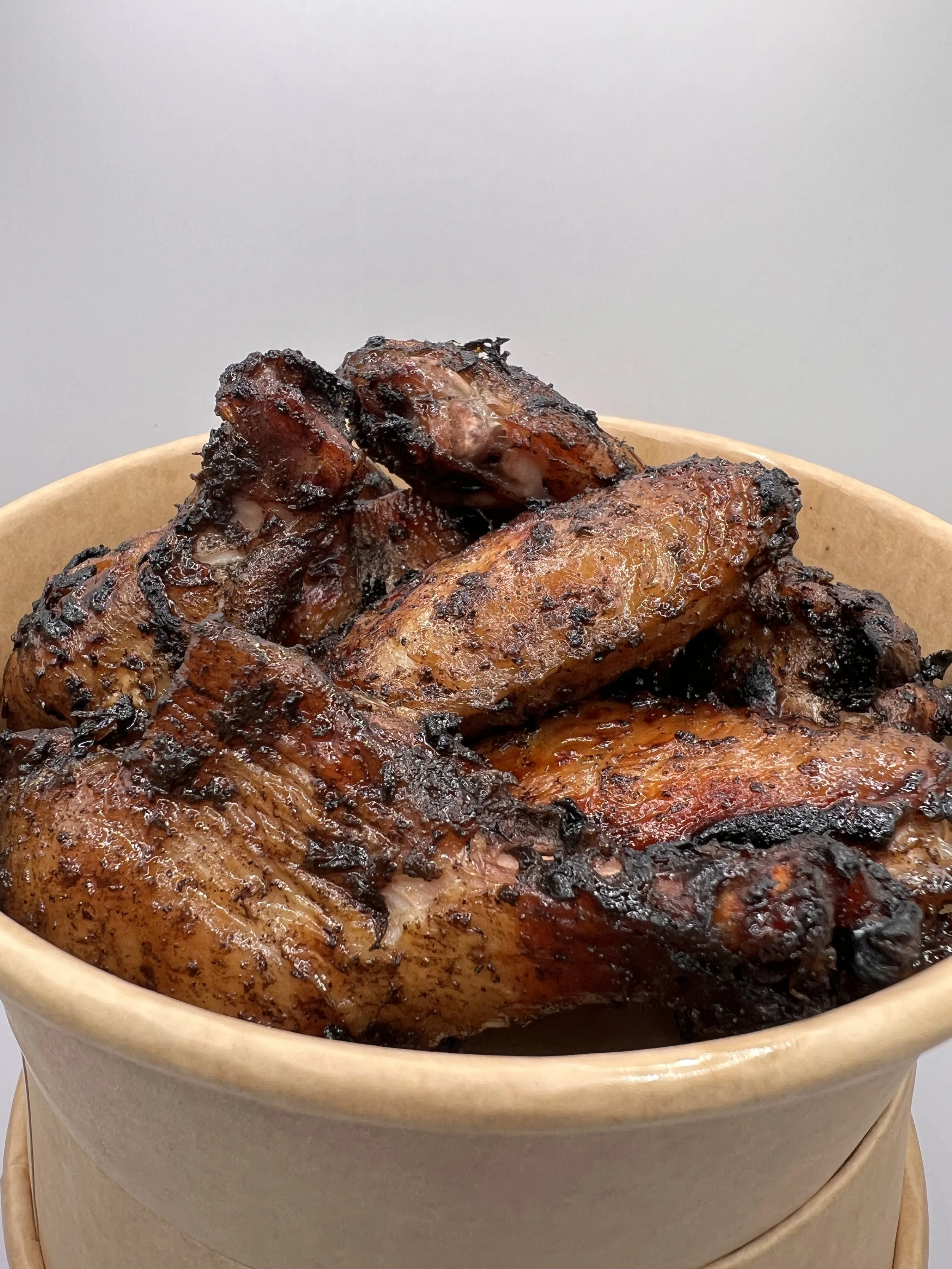 Close-up of a baked, glazed ham with a caramelized crust in a round wooden bowl.