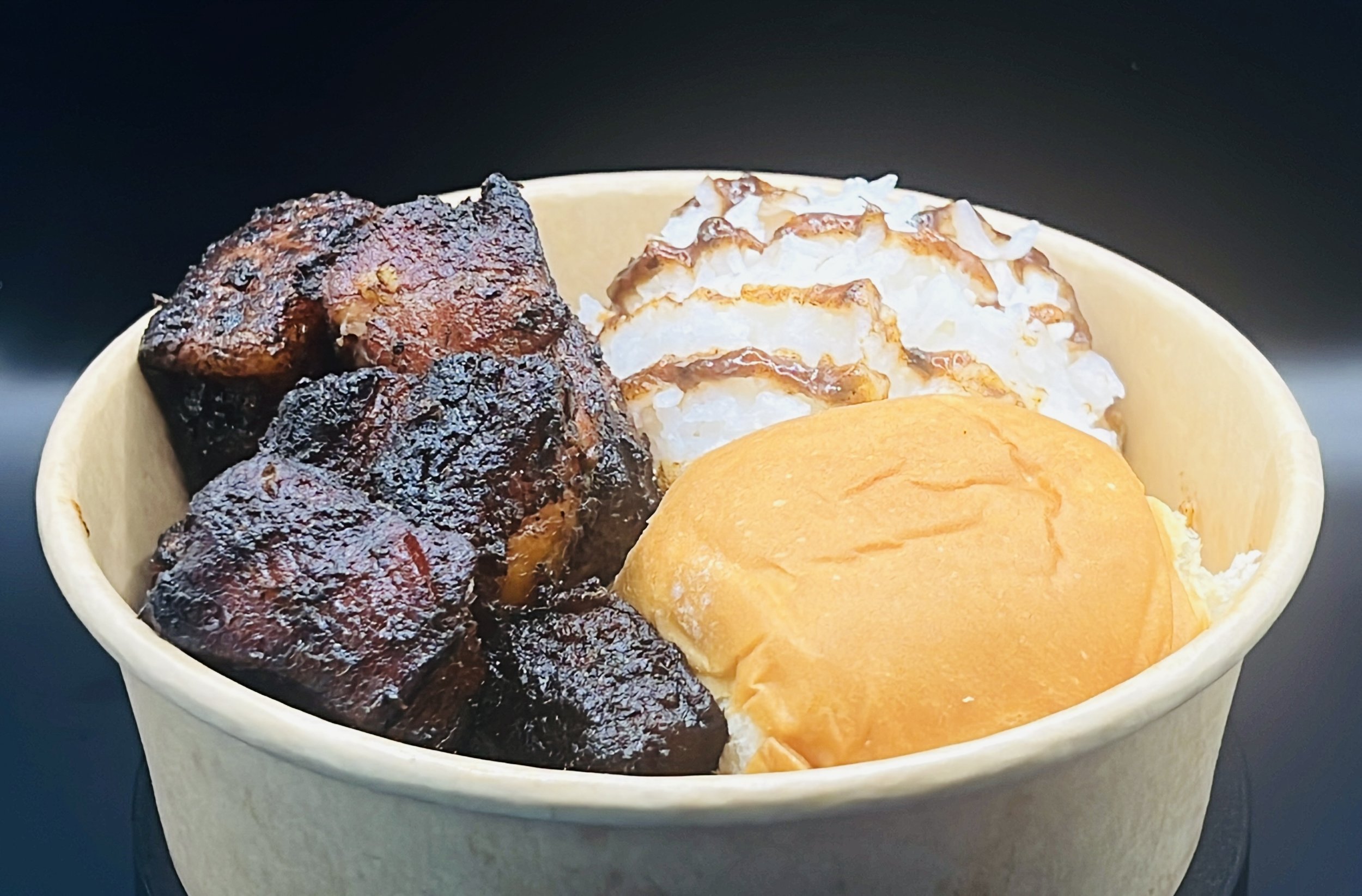 A bowl of assorted desserts including large dark chocolate brownies, a dollop of whipped cream topped with caramel drizzle, and a scoop of orange-flavored ice cream.